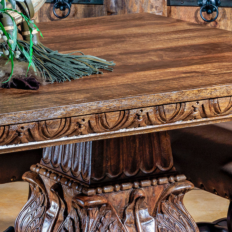 Live-edge Western dining table made from solid reclaimed wood with forged-iron base and natural grain texture close-up.