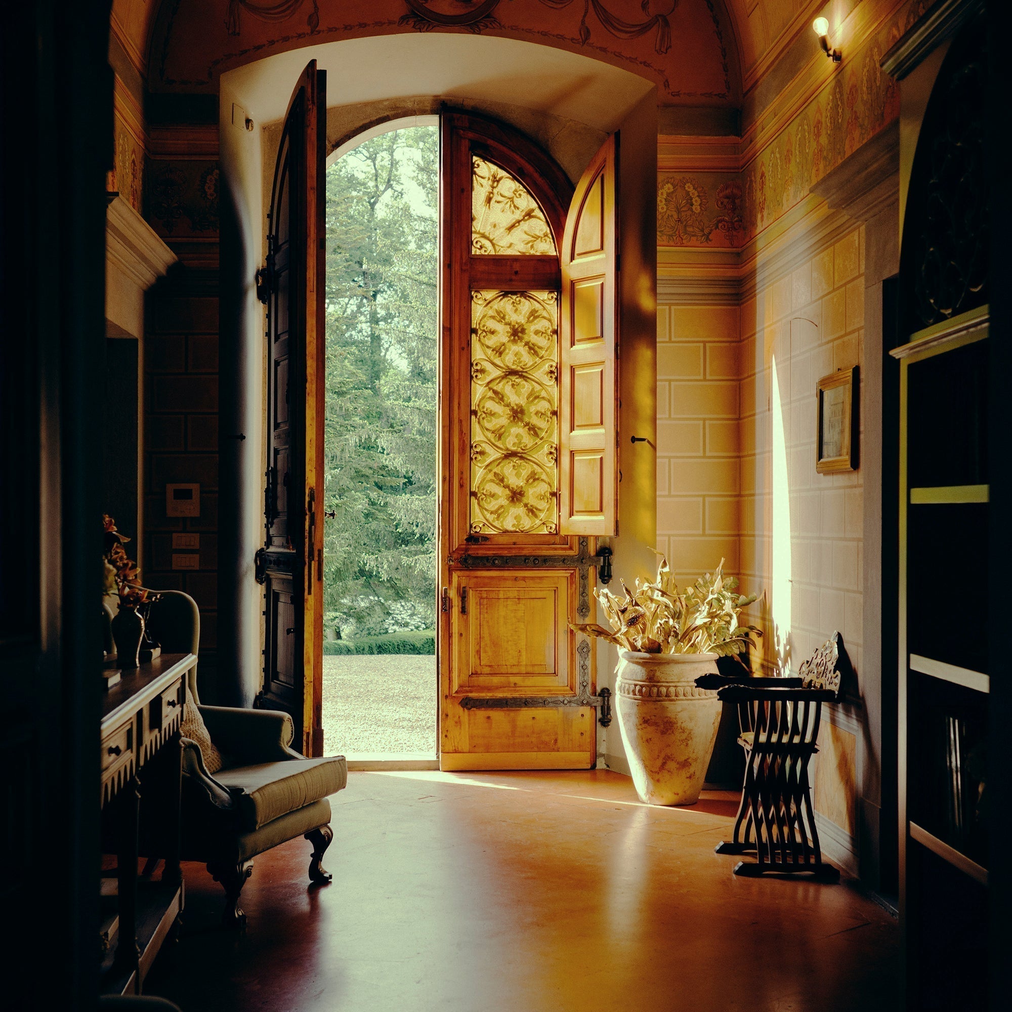Western entryway with carved wood console, iron mirror, leather bench, and warm lighting