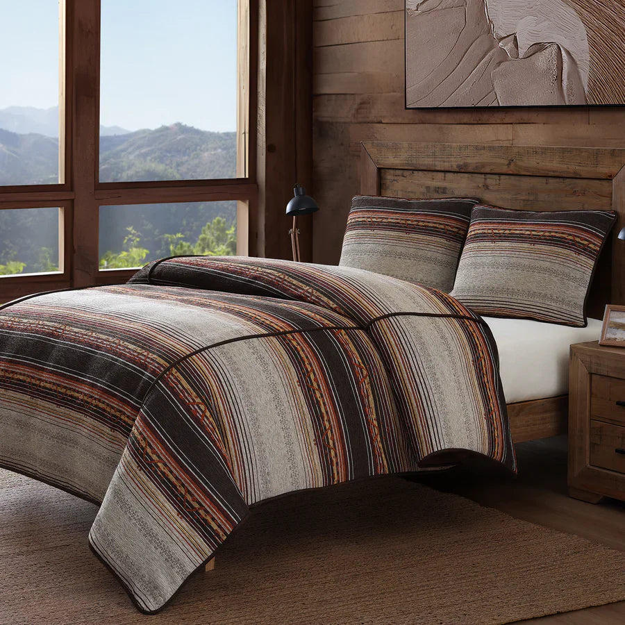 Rustic Western bedding set in a luxury ranch-style bedroom with leather and textile accents