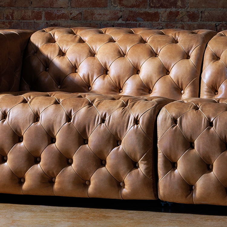 Western leather sofa with cowhide accents and hand-carved wood detailing, ideal for luxury ranch interiors