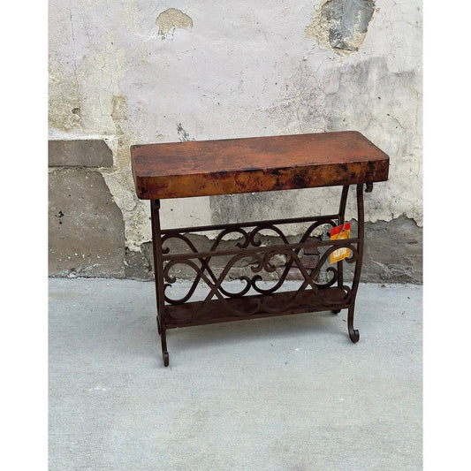 Experience the unique combination of industrial and rustic style with the Copper Magazine Table. Crafted from hand-forged iron and hammered copper, this side table is sure to add a modern, functional touch to any room. Its ample surface space provides the perfect place for your favorite magazine or book.