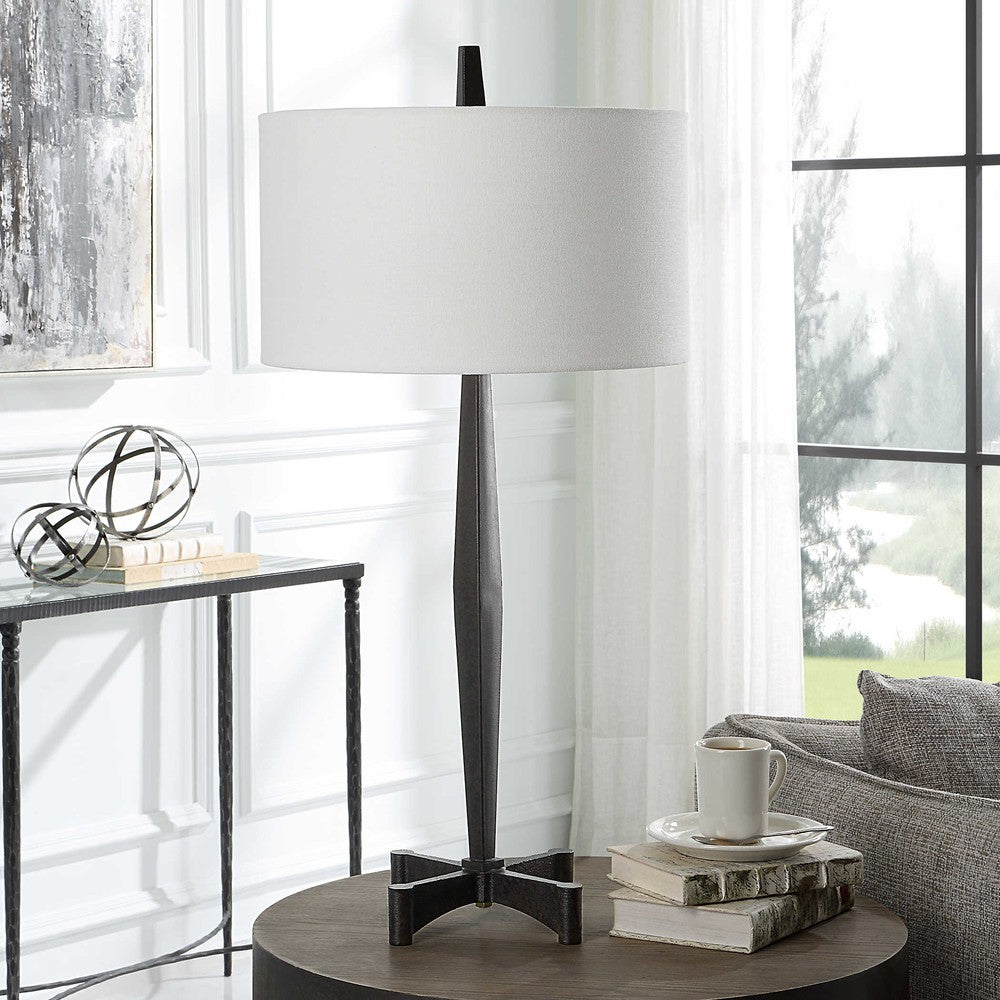 This classic metalwork inspired table lamp is perfect for any industrial decor. Constructed with a tapered base and aged black finish, its subtle rust distressing adds an authentic vintage touch. Enjoy the perfect ambiance when you turn on the Counteract Table Lamp.