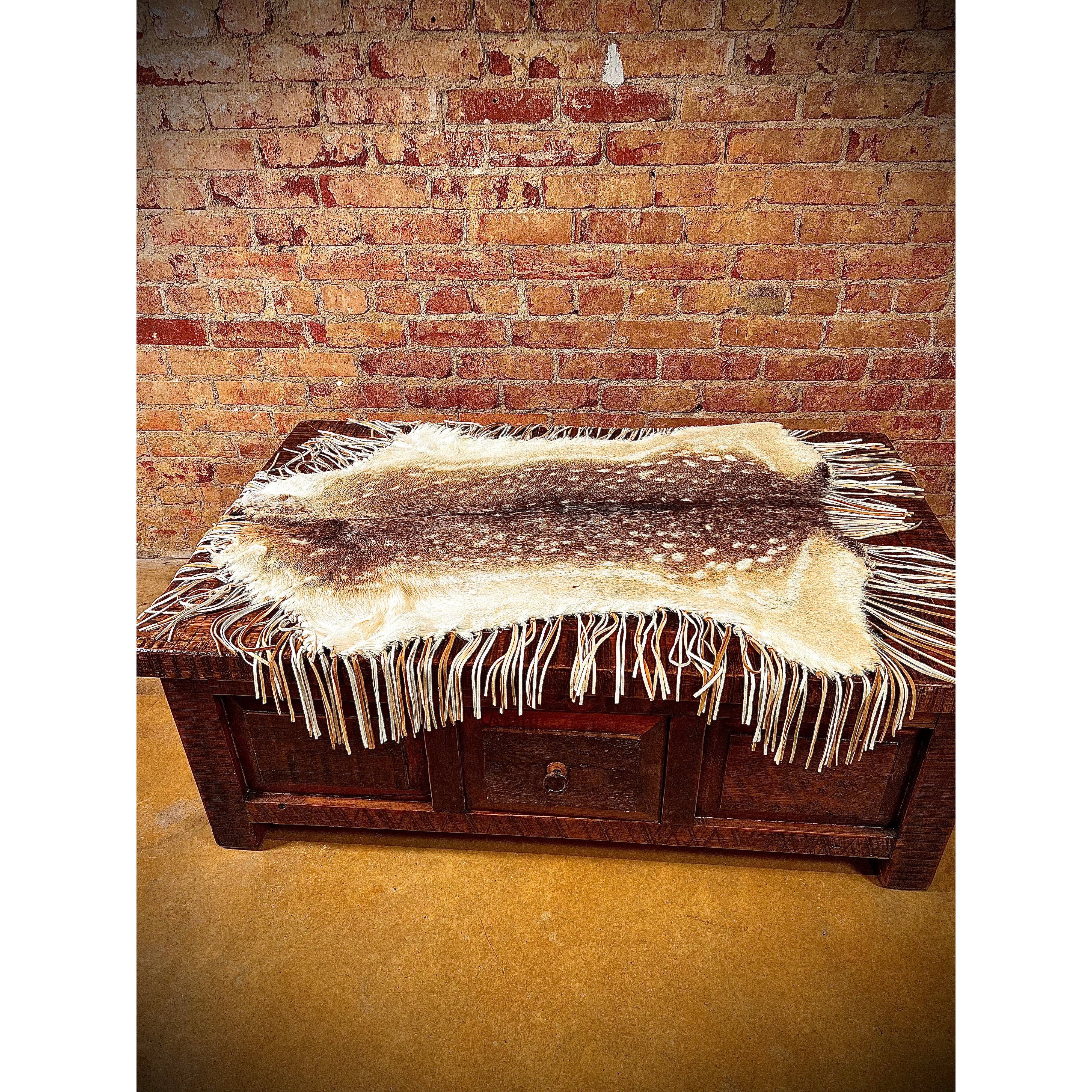 Enhance the aesthetic of your coffee table or dining table with our premium Fallow Deer Hide Table Topper. Made from luxurious fallow deer hide, this topper features a stunning leather fringe detail for added elegance. Perfect for adding a touch of sophistication to any table setting. Ships within one week.