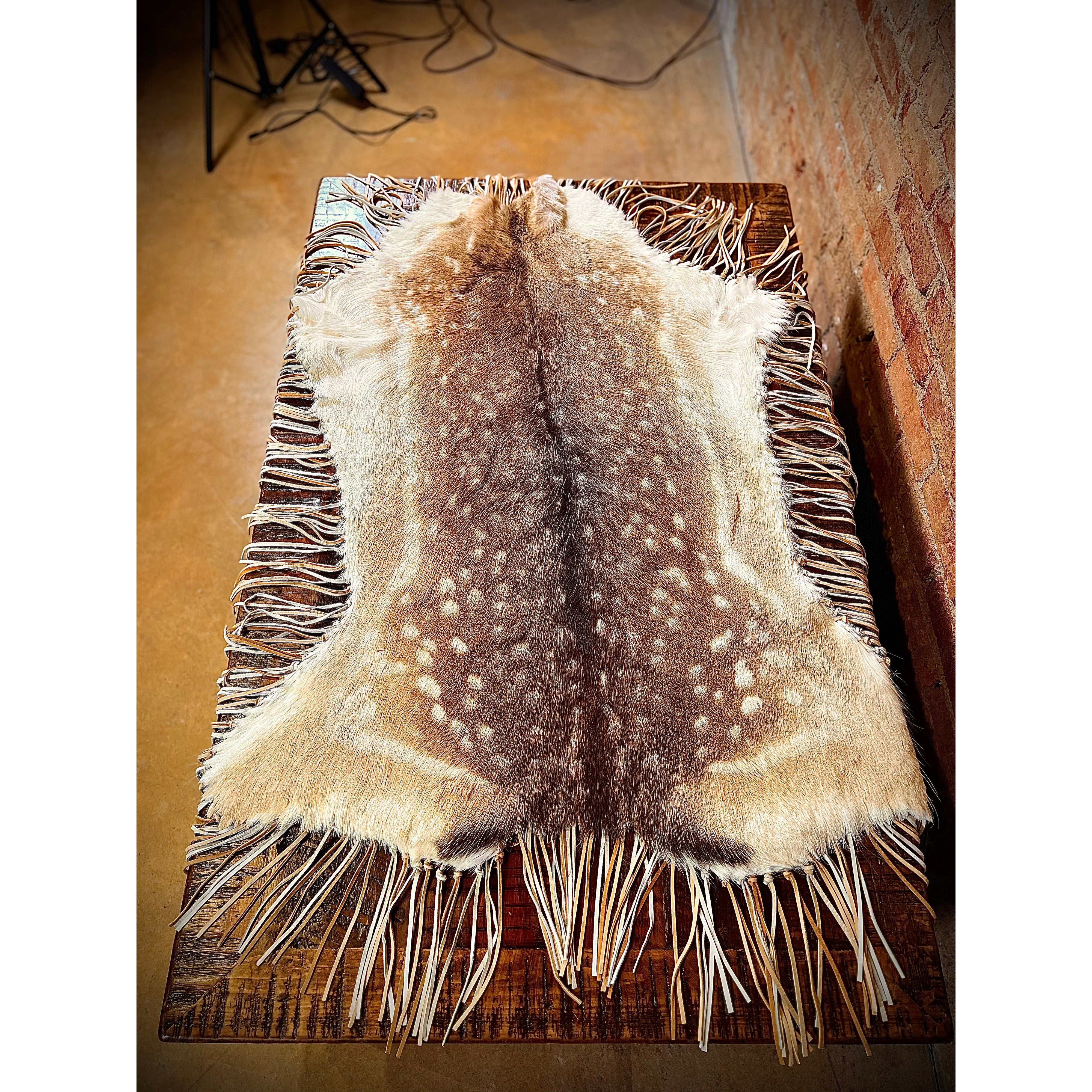 Enhance the aesthetic of your coffee table or dining table with our premium Fallow Deer Hide Table Topper. Made from luxurious fallow deer hide, this topper features a stunning leather fringe detail for added elegance. Perfect for adding a touch of sophistication to any table setting. Ships within one week.