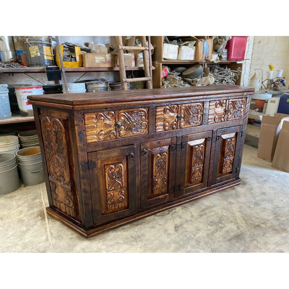 This beautiful hand-carved angled credenza is crafted from solid reclaimed wood, perfect for an entertainment stand or buffet. Its unique design adds a touch of elegance to any living space, and its sturdy construction ensures it can stand the test of time. Perfect for any home.