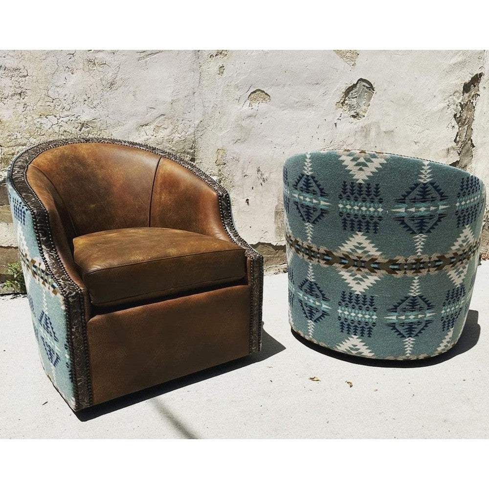 This Rancho Arroyo Shale Barrel Chair offers a luxurious seating experience with its swivel design upholstered with top grain leather and stamped leather trim. The ornamental Pendleton fabric adds an elegant touch. Perfect for modern or ranch house living rooms.