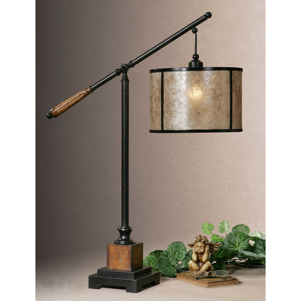 The Sitka Table Lamp features an aged black metal base accented with rustic mahogany and light rottenstone glaze solid wood details, plus a round drum shade of natural mica with aged black trim. This classic design is sure to lend a timeless look to any space.