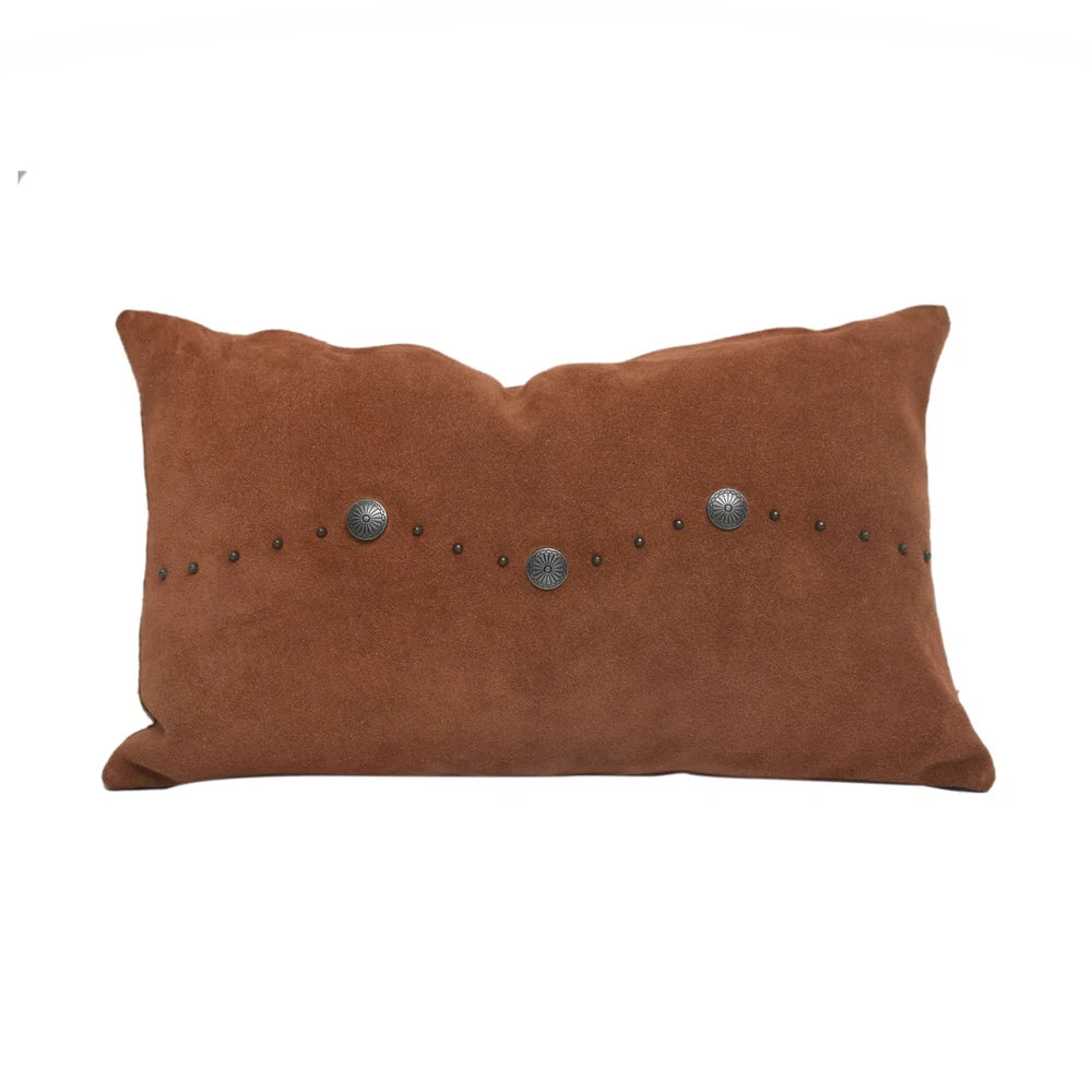 Classically crafted in suede, this Western Concho Pillow is perfect for any living space. Boasting a single silver concho center and a silver-studded border, its rustic elegance is available in four versatile shades: black, gray, navy, and tobacco. Add a luxurious touch to your the home with this timeless option.