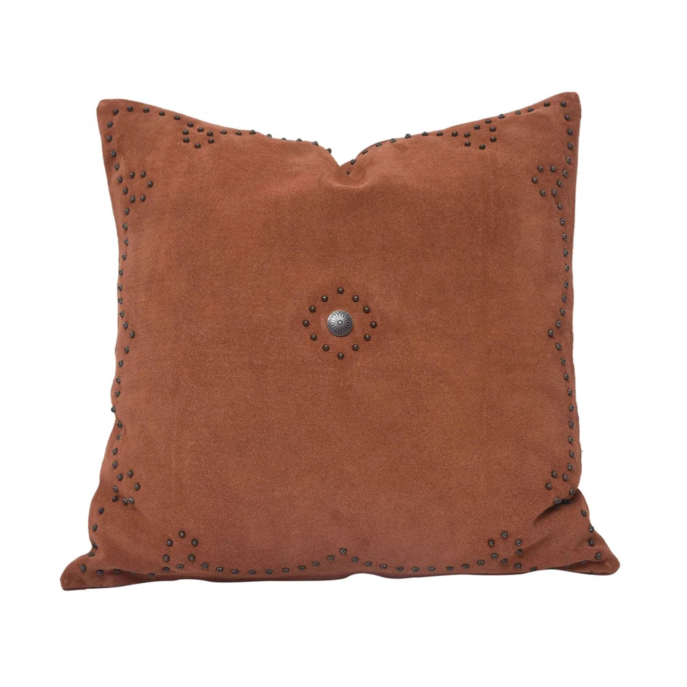 Classically crafted in suede, this Western Concho Pillow is perfect for any living space. Boasting a single silver concho center and a silver-studded border, its rustic elegance is available in four versatile shades: black, gray, navy, and tobacco. Add a luxurious touch to your the home with this timeless option.