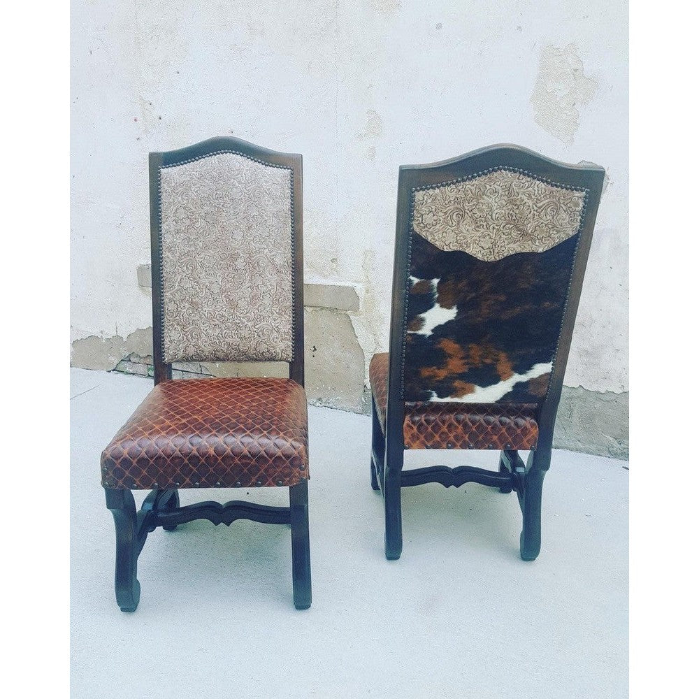 Experience luxurious comfort and style with the Tolbert Dining Chair. It is expertly crafted with top grain leather and tri-colored cowhide upholstery, providing a plush seating experience. With a diamond stitch seat and solid wood frame and trim, this chair adds both glamour and durability to any room.