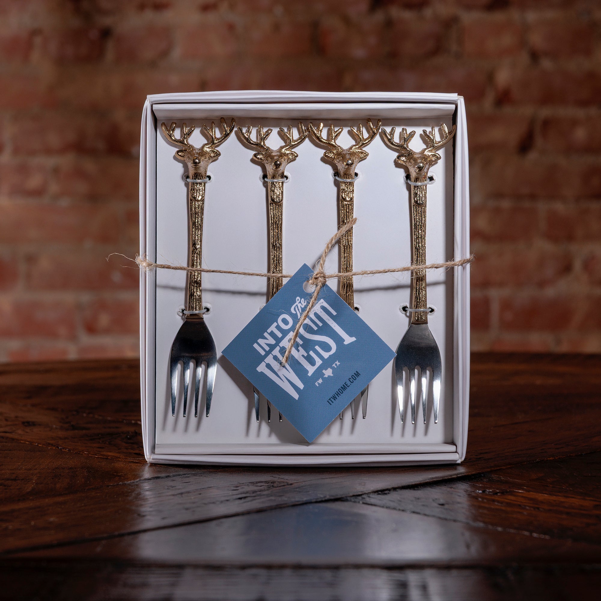 Gift-boxed gold antler handle appetizer fork set of four on rustic wood surface