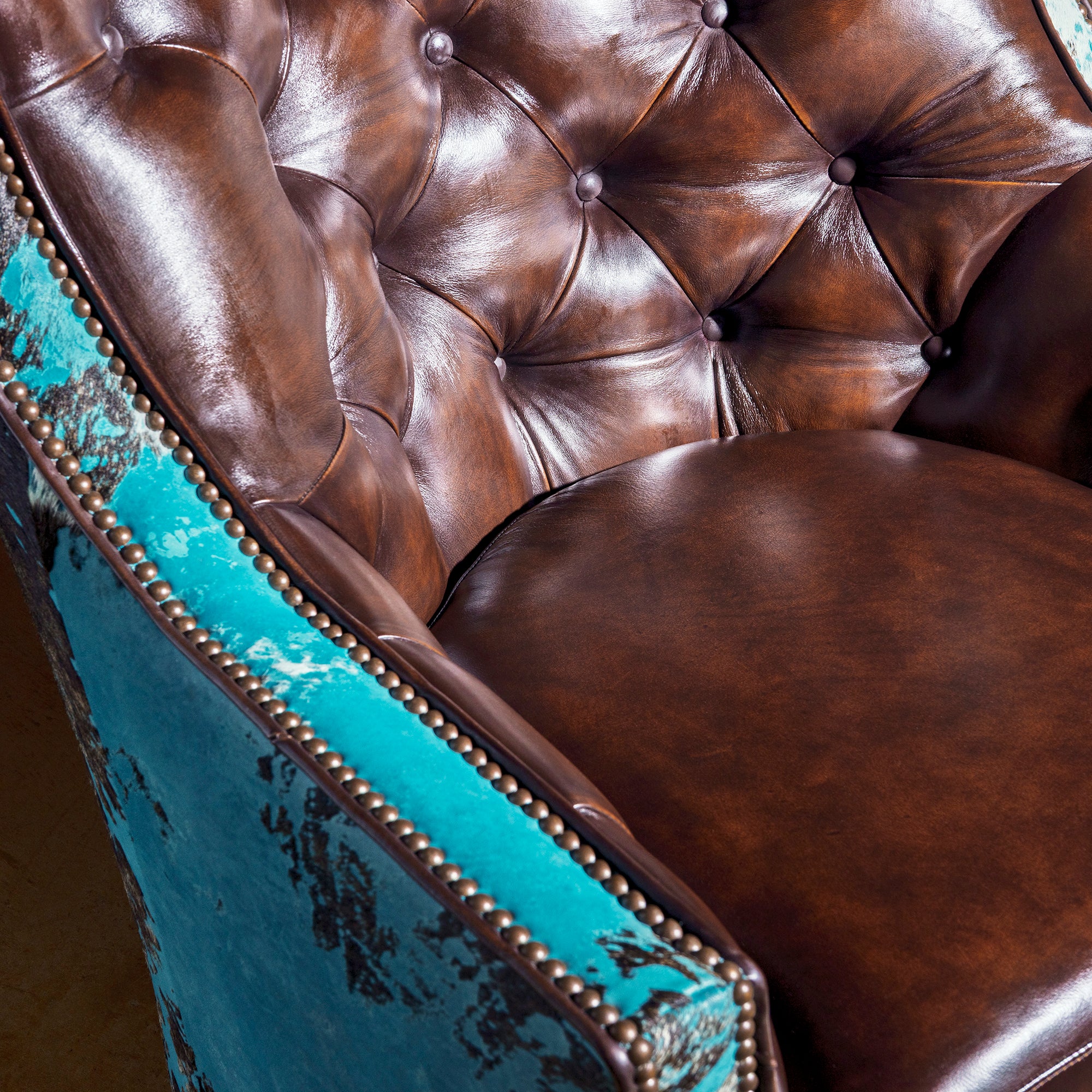 Azure Spur Tufted Western Swivel Chair western swivel chair seat detail with top-grain leather, nailhead trim, and turquoise hide side panel.