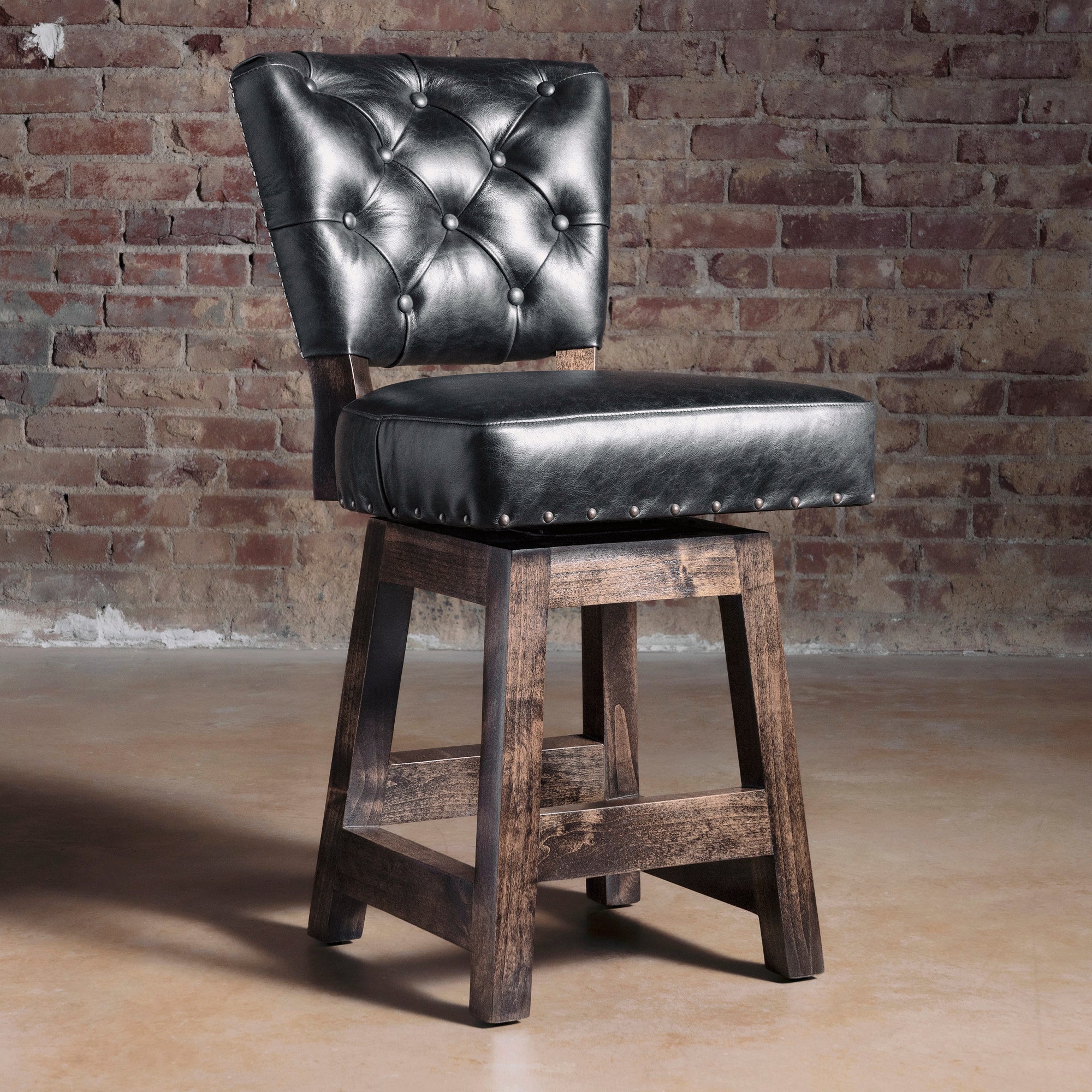Black tufted leather Western bar stool with alder wood frame, dark stained legs, and nailhead trim—luxury ranch bar seating