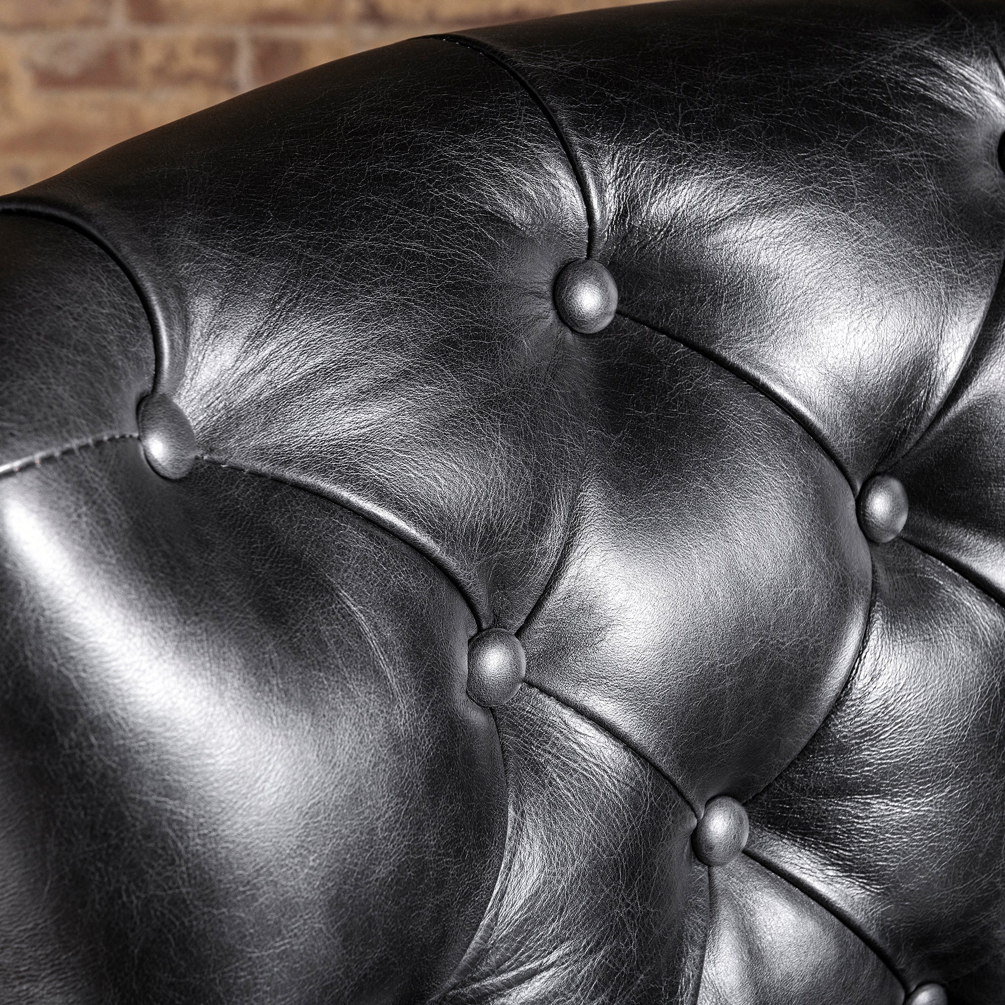 Close-up of button-tufted black leather backrest on Western bar stool—tailored leather upholstery detail for ranch home bar