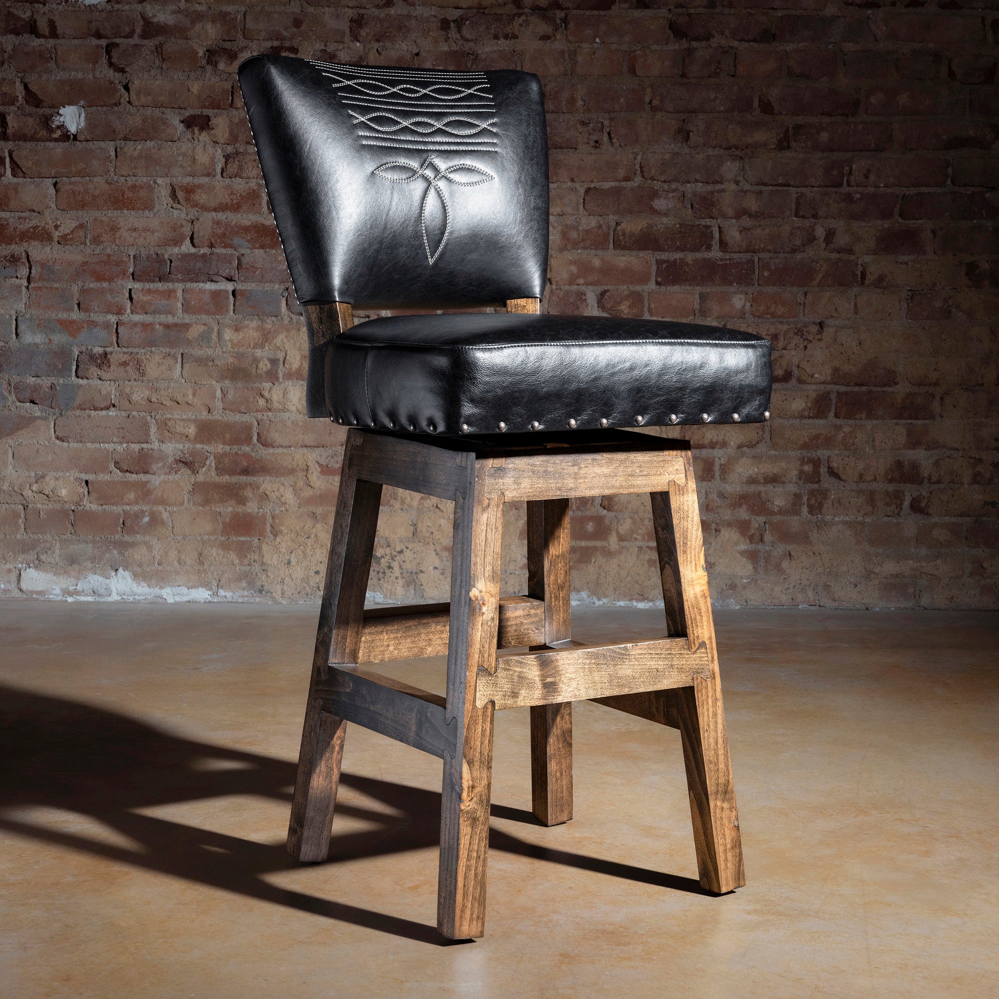Black leather Western bar stool with bootstitch embroidery and rustic Alder wood base, armless profile