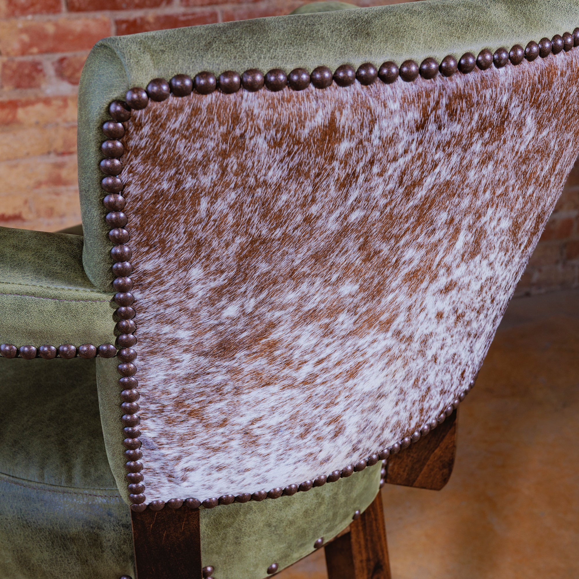 Back view of Western bar stool showcasing Brazilian cowhide upholstery and nailhead trim