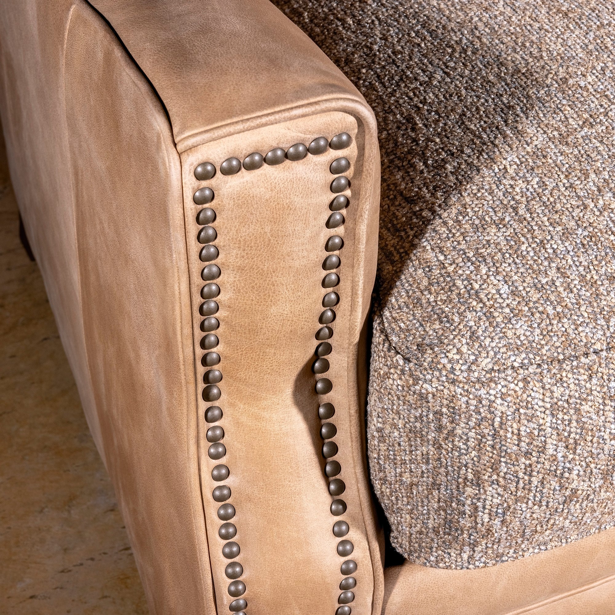 Bridger Nailhead Sofa western sofa showing leather arm, nailhead trim, tapered wood leg, and ranch-lodge detail