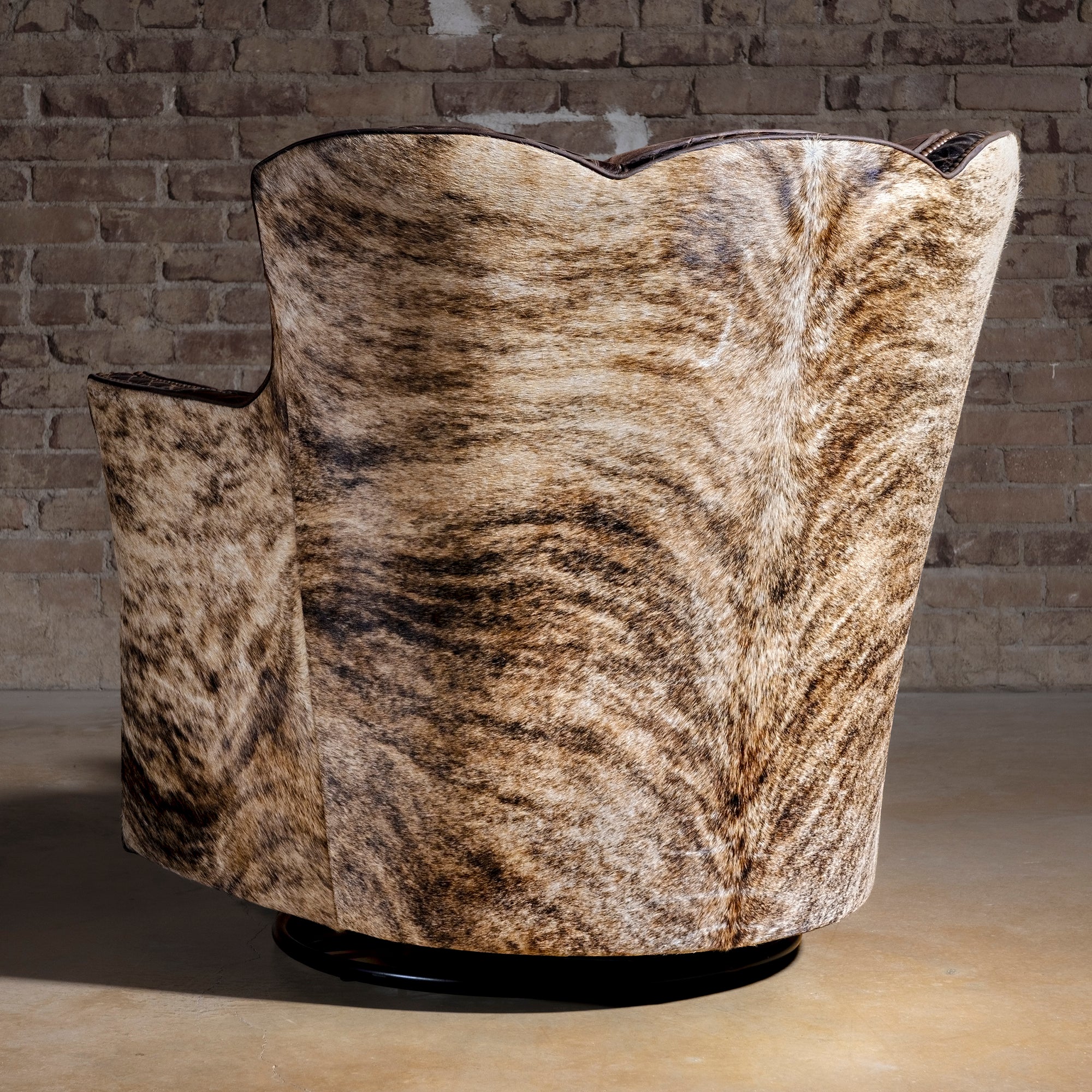 Brindle Cavalier Cowhide Western Swivel Chair rear view with full Brazilian cowhide wrap, sculpted wingback, and 360-degree base.