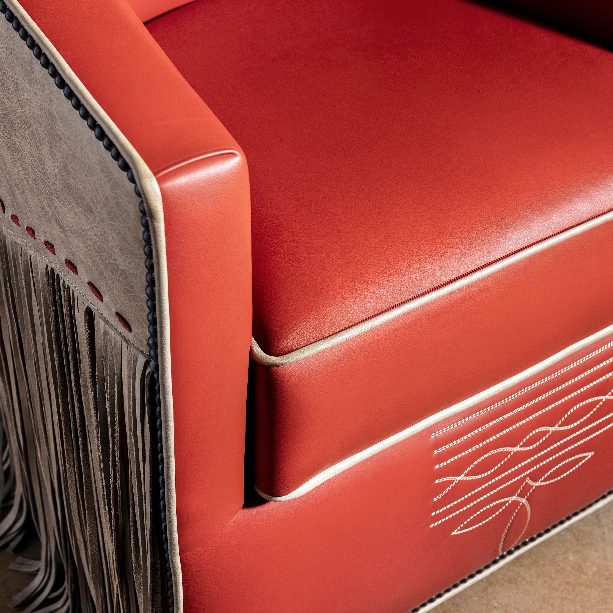 High-angle closeup showing smooth leather, piping, and refined upholstery finish