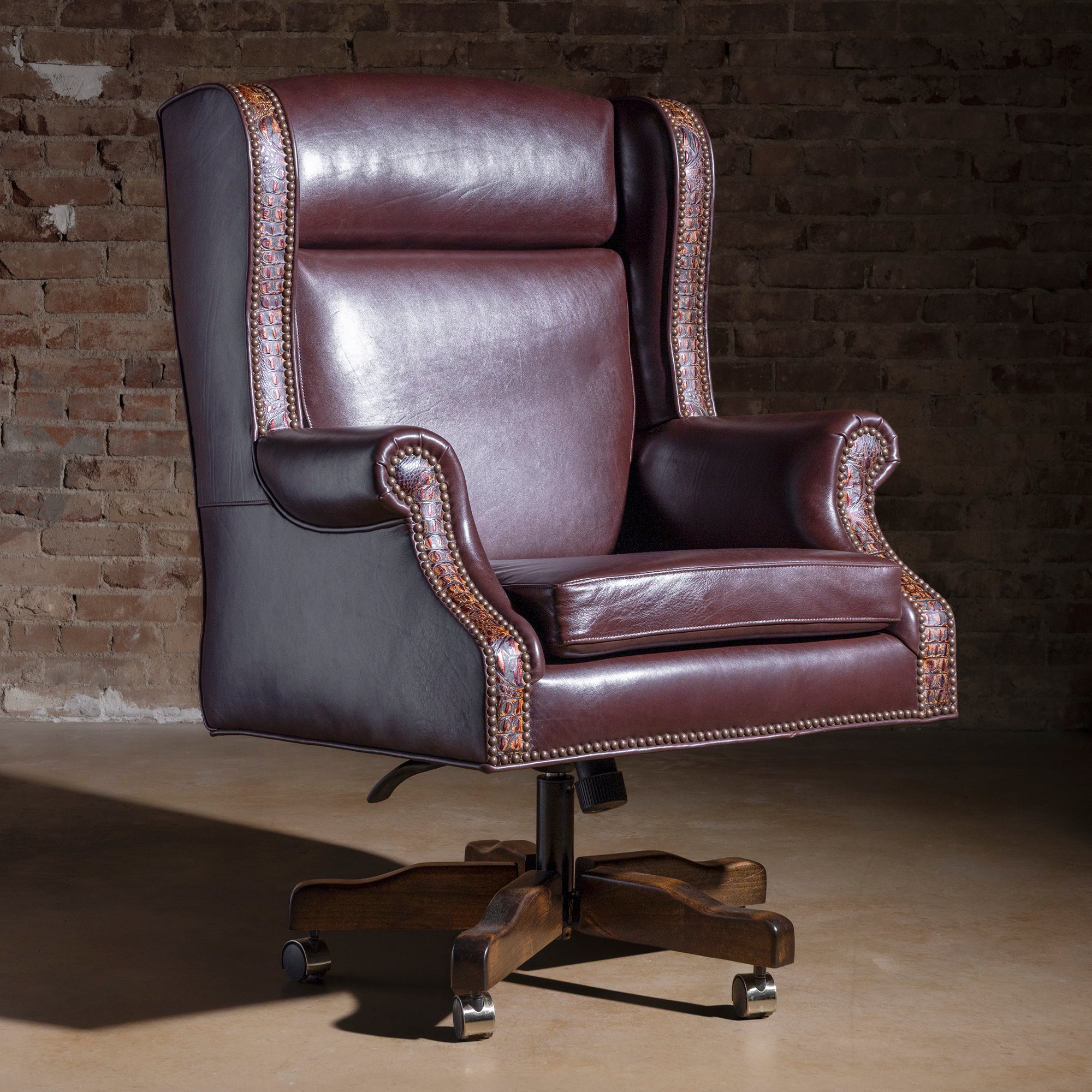 Leather desk chair with tooled leather accents, nailhead trim, and swivel caster base