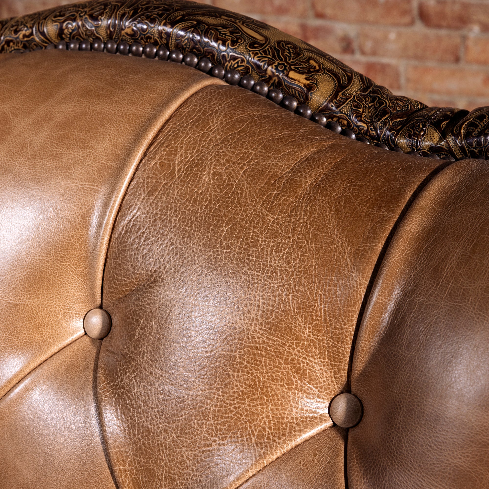 Close-up of saddle-toned top-grain leather texture on tufted Western sofa