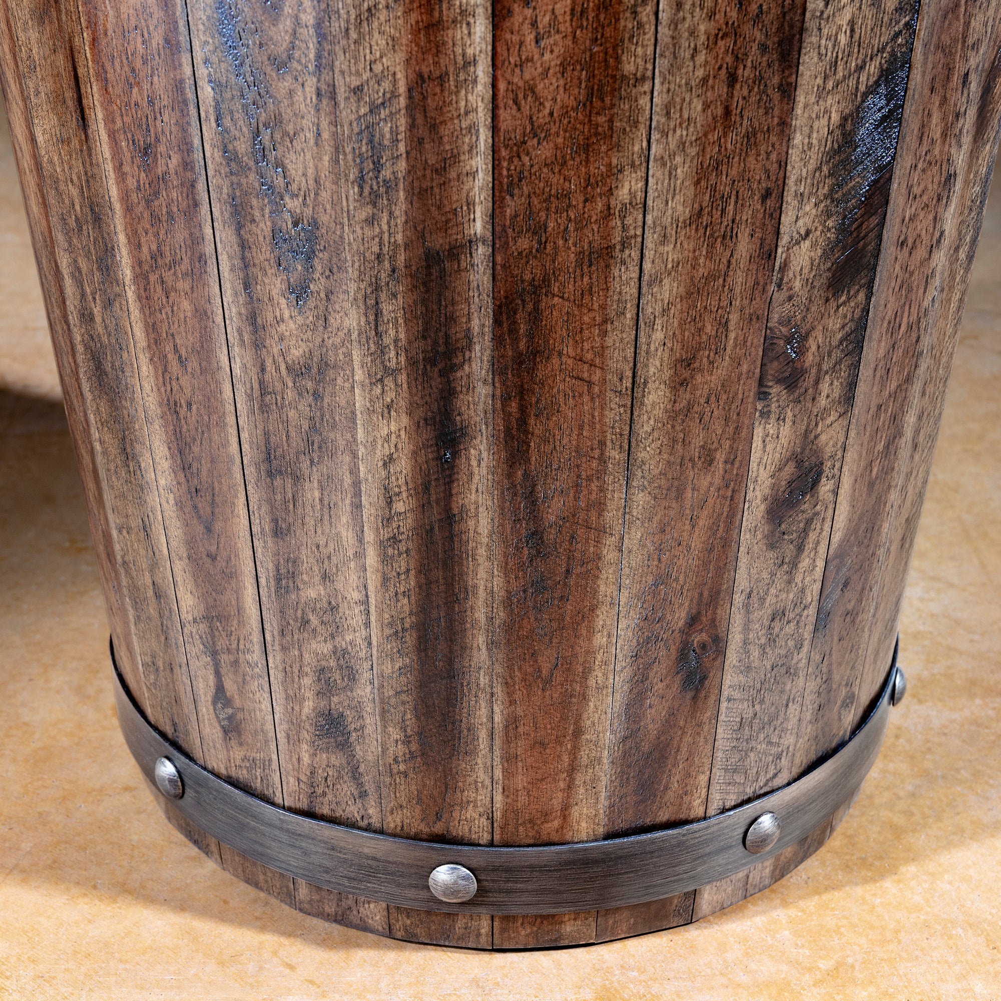 Close-up of reclaimed wood staves and riveted dark metal band on barrel accent table