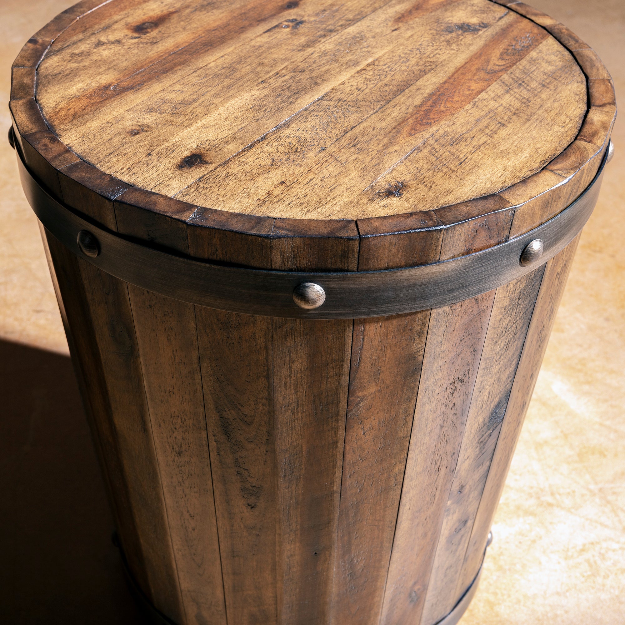 Angled top-side view of barrel accent table showing banded rim and rivet hardware