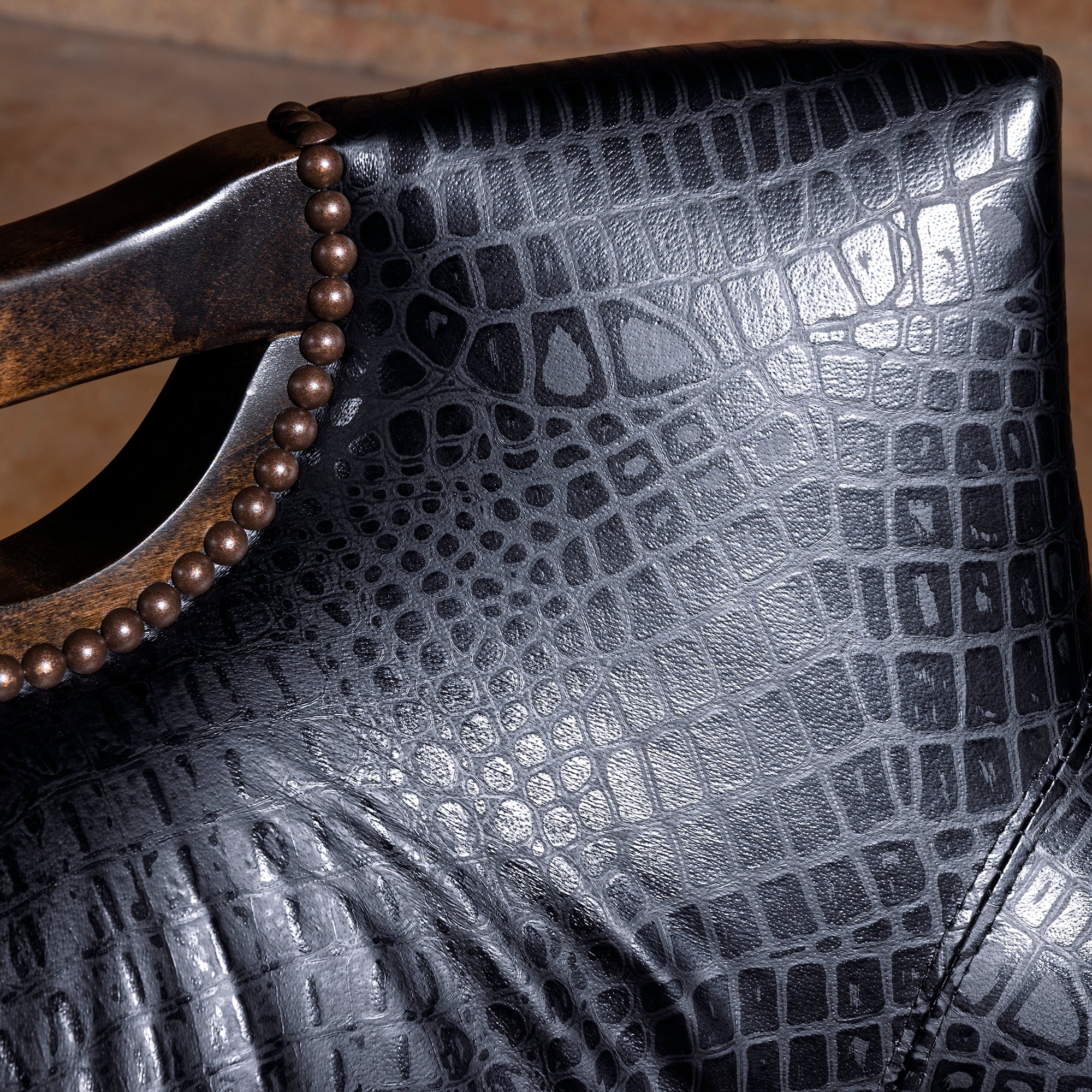 Closeup of black croc-embossed leather upholstery on luxury Western game room chair