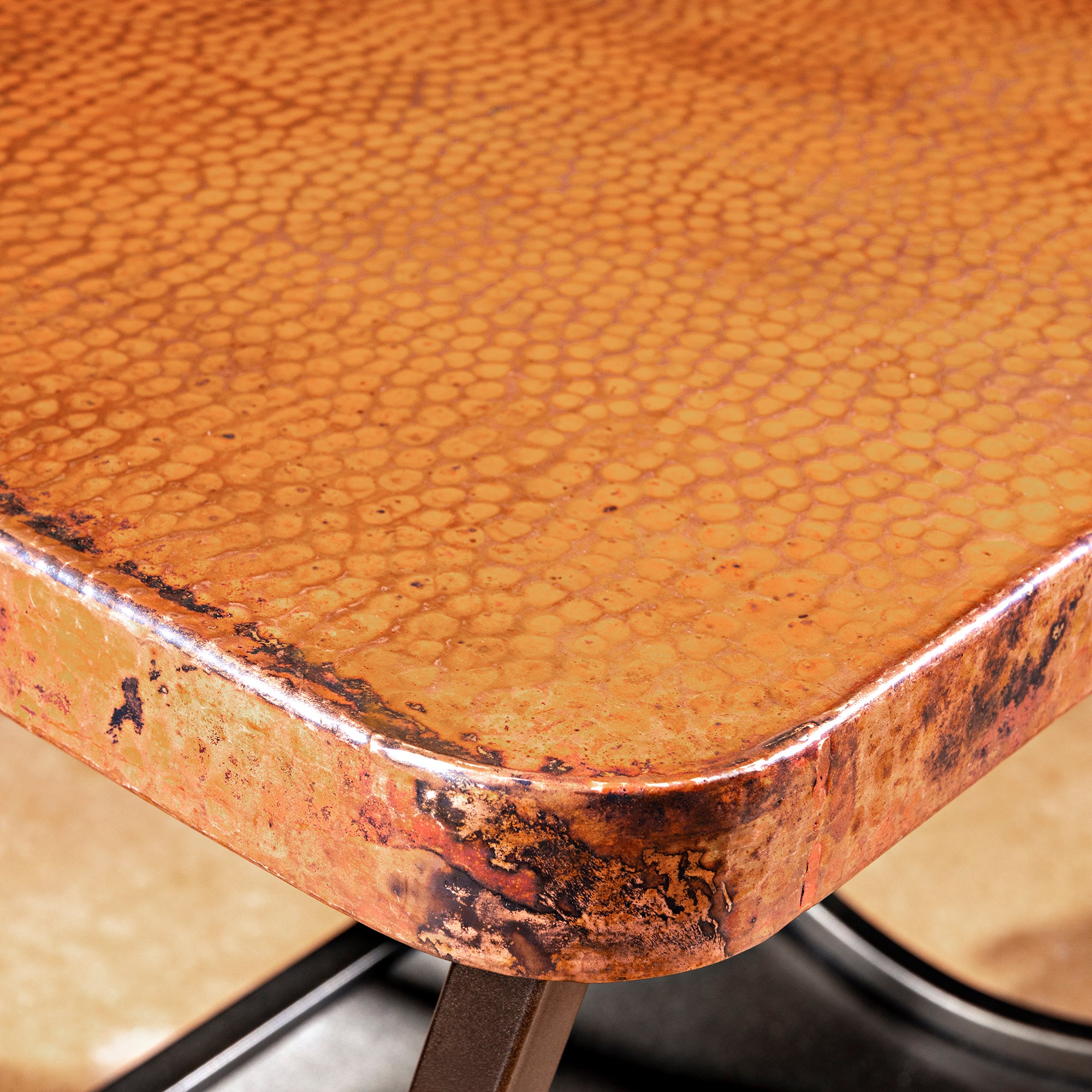 Cobre Scroll Table close detail of hammered copper tabletop with burnished Western texture and rounded square edge