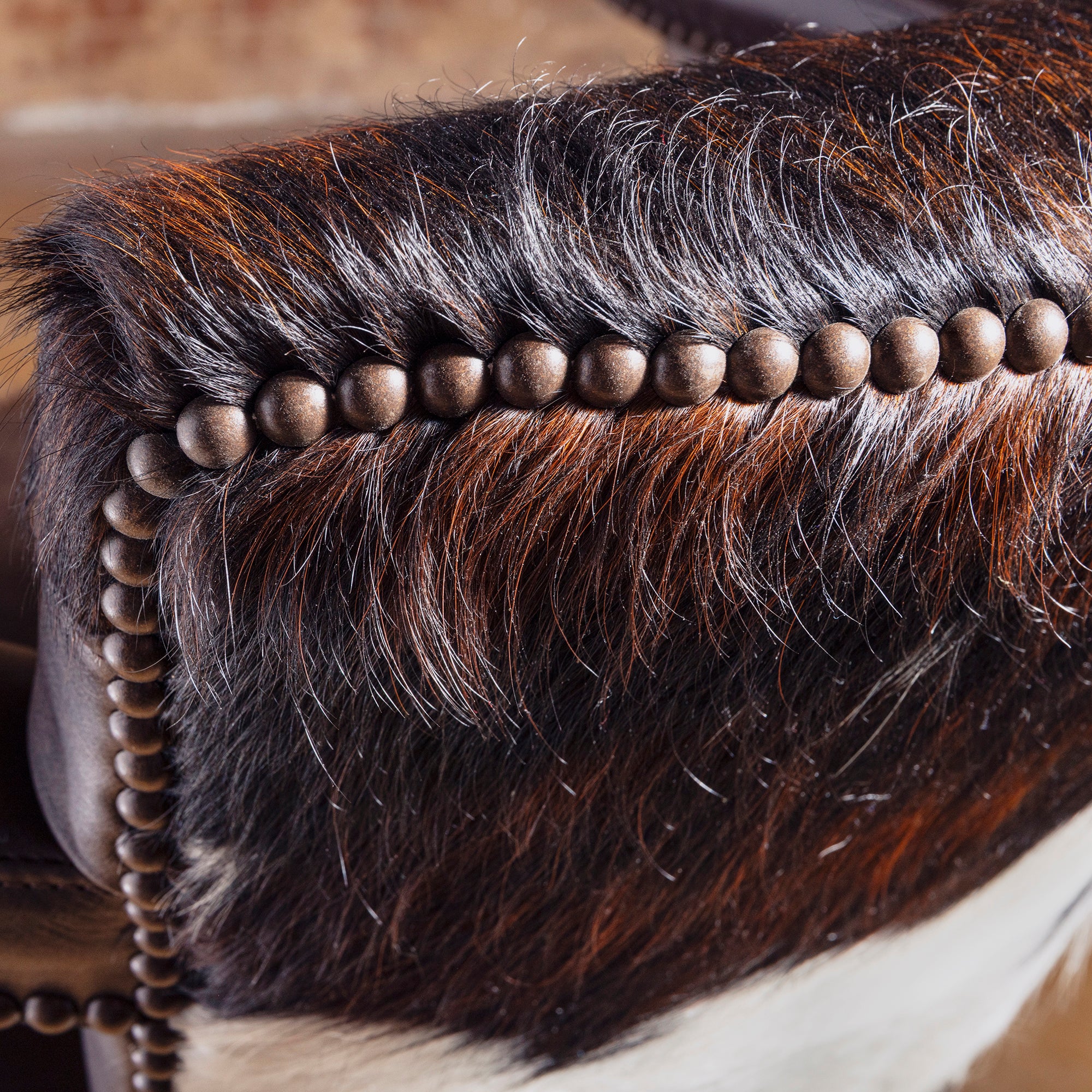 Close-up of cowhide back with leather yoke seam and nailhead detailing on Cochise Western bar stool