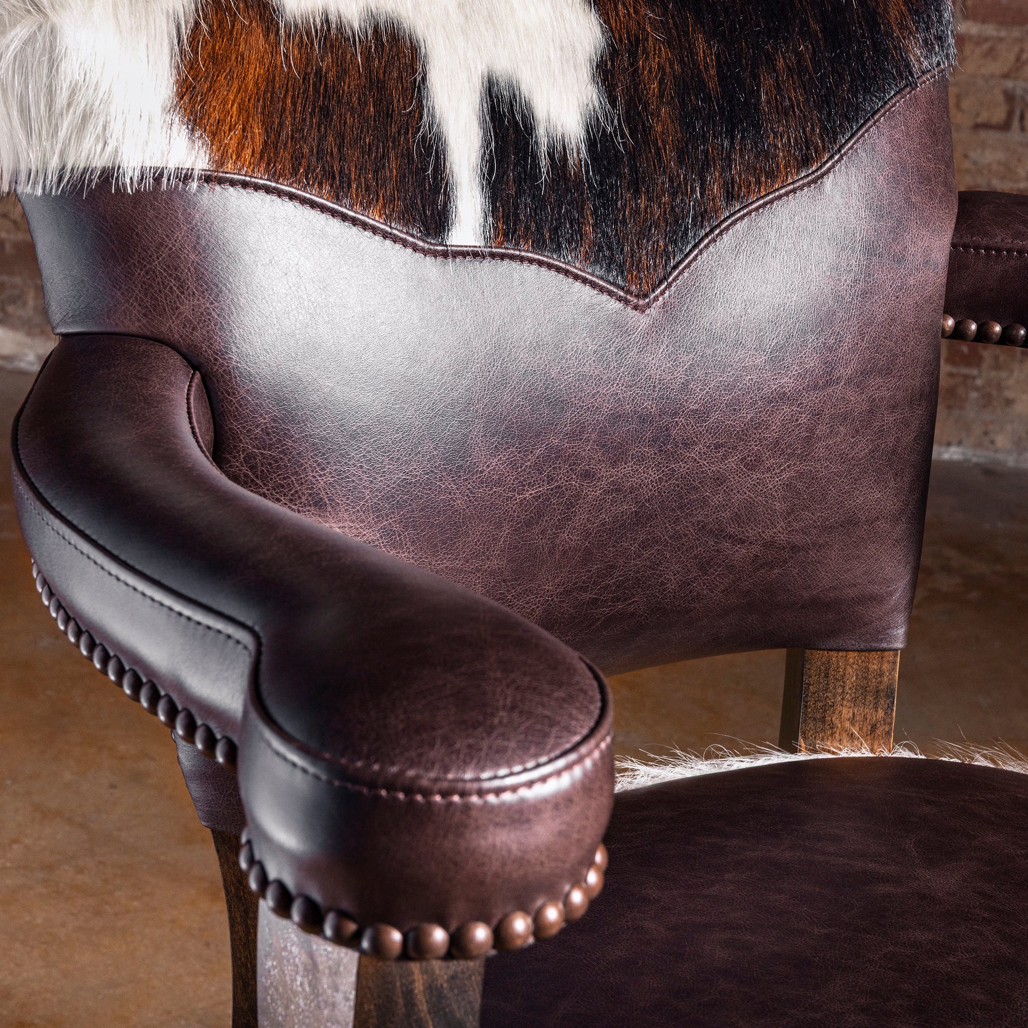 Close-up of tricolor cowhide upholstery with nailhead trim on Cochise Western leather bar stool