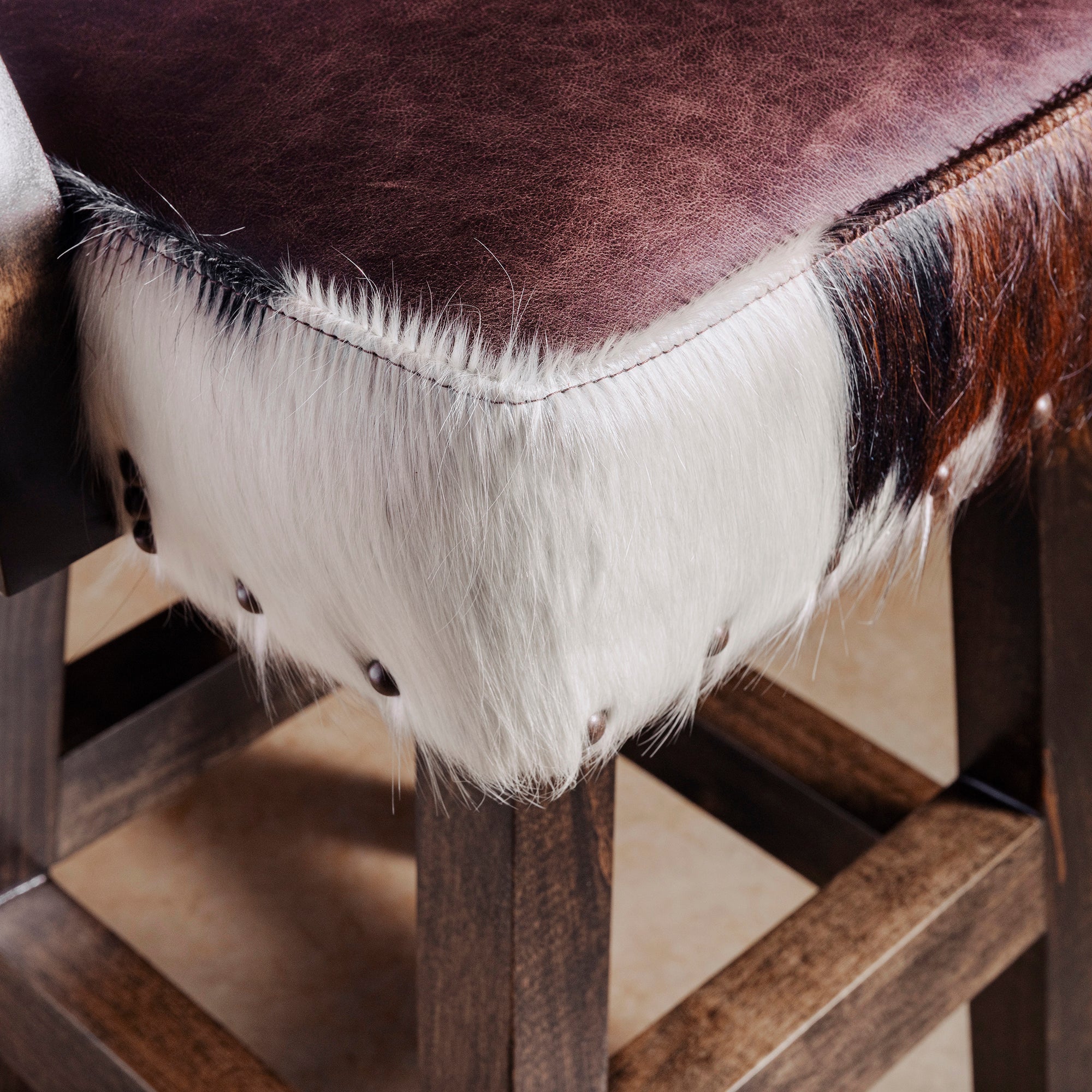 Seat detail showing dark leather upholstery, nailhead trim, and plush cushioning on Cochise Western bar stool with arms