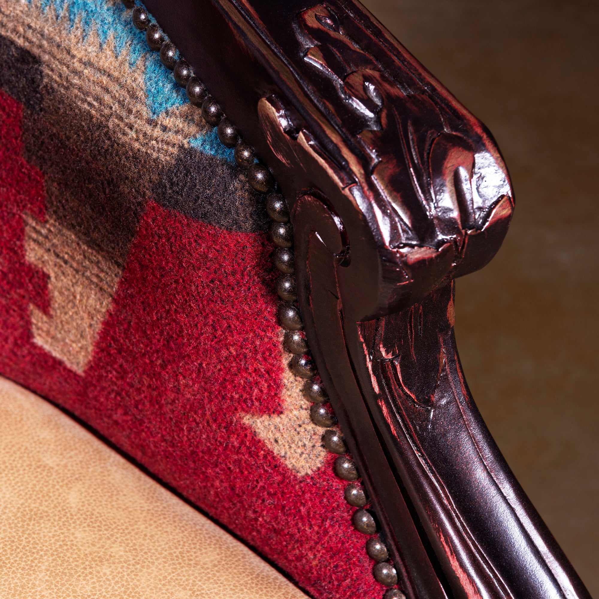 Carved wood arm detail with nailhead trim on Western accent chair
