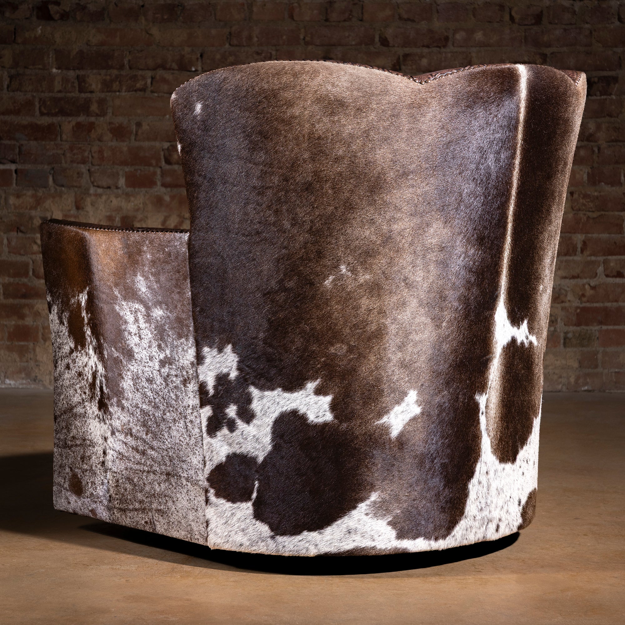 Back view of Conch Canyon Swivel Chair showing natural Brazilian cowhide pattern