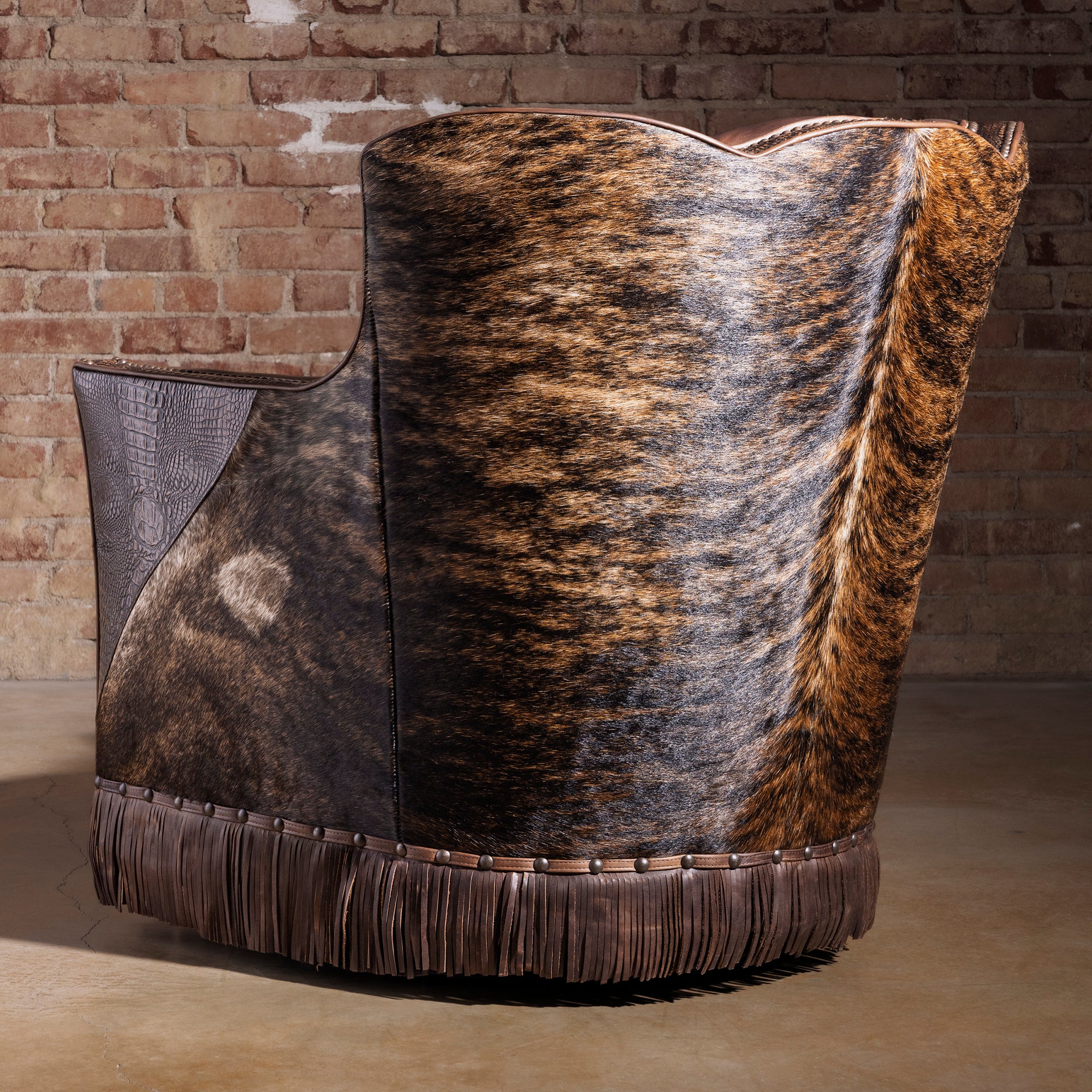 Back view of brindle cowhide swivel chair with Western leather fringe base