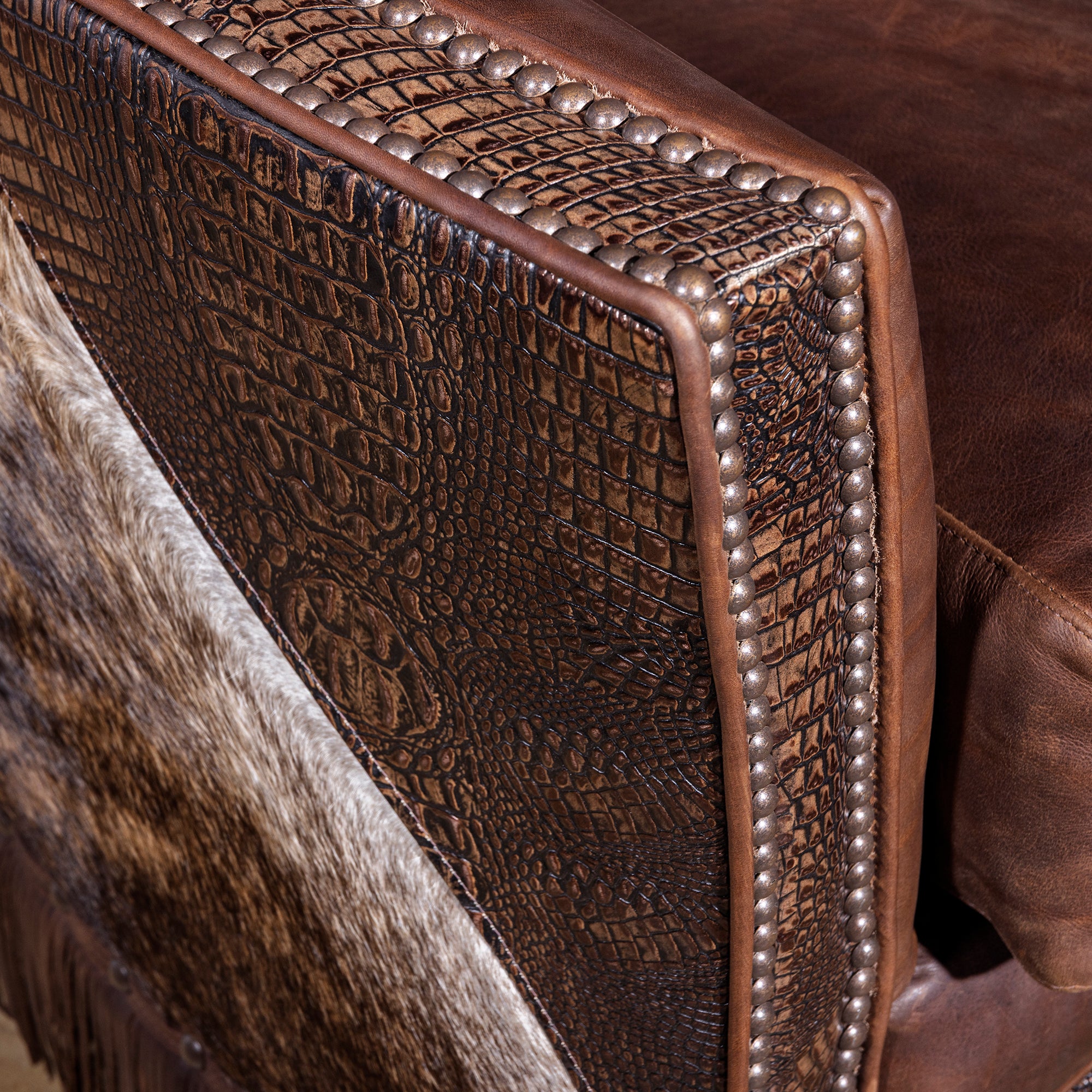 Close-up of croc-embossed leather trim and nailhead detail on swivel chair