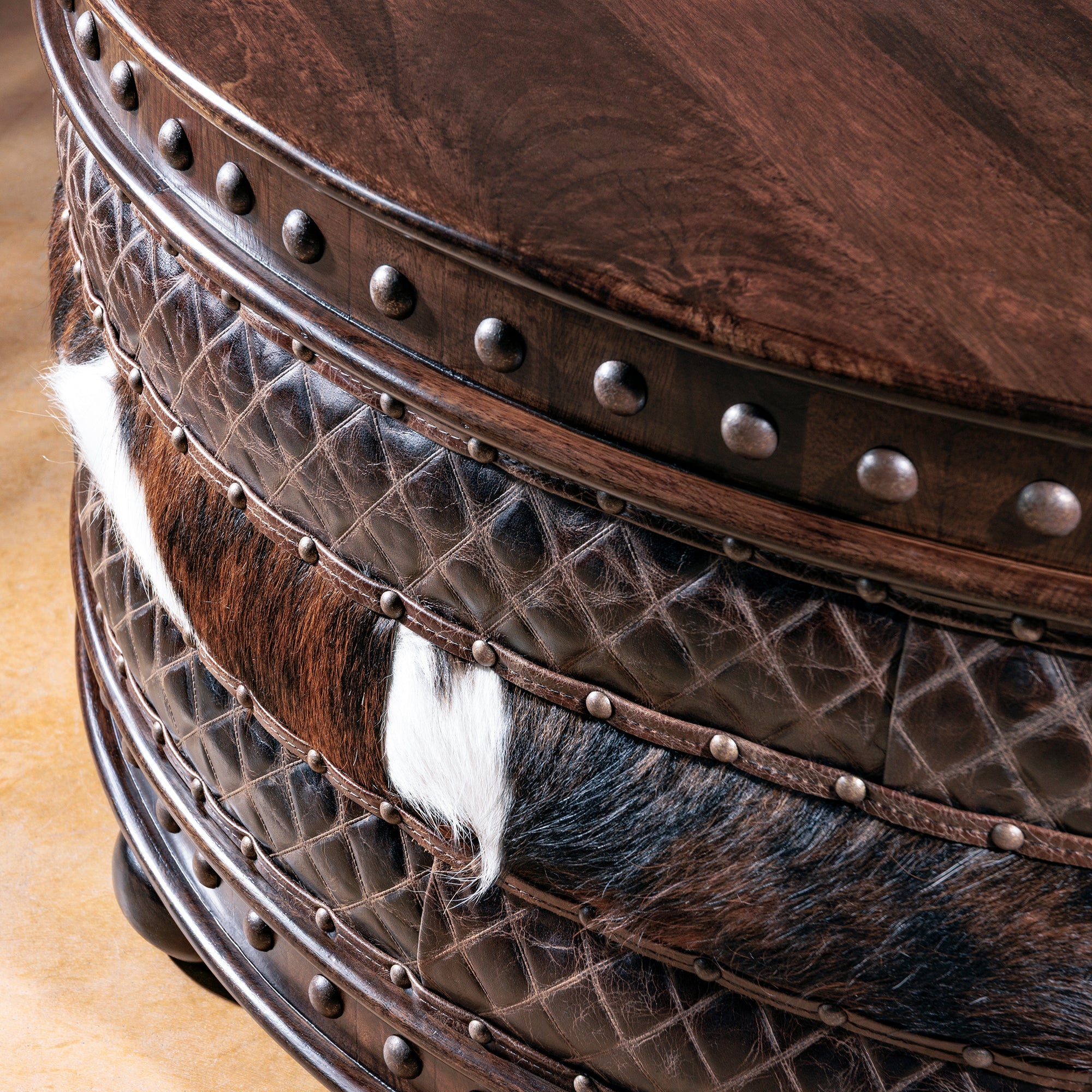 Detail of quilted leather and cowhide bands with rustic nailhead accents