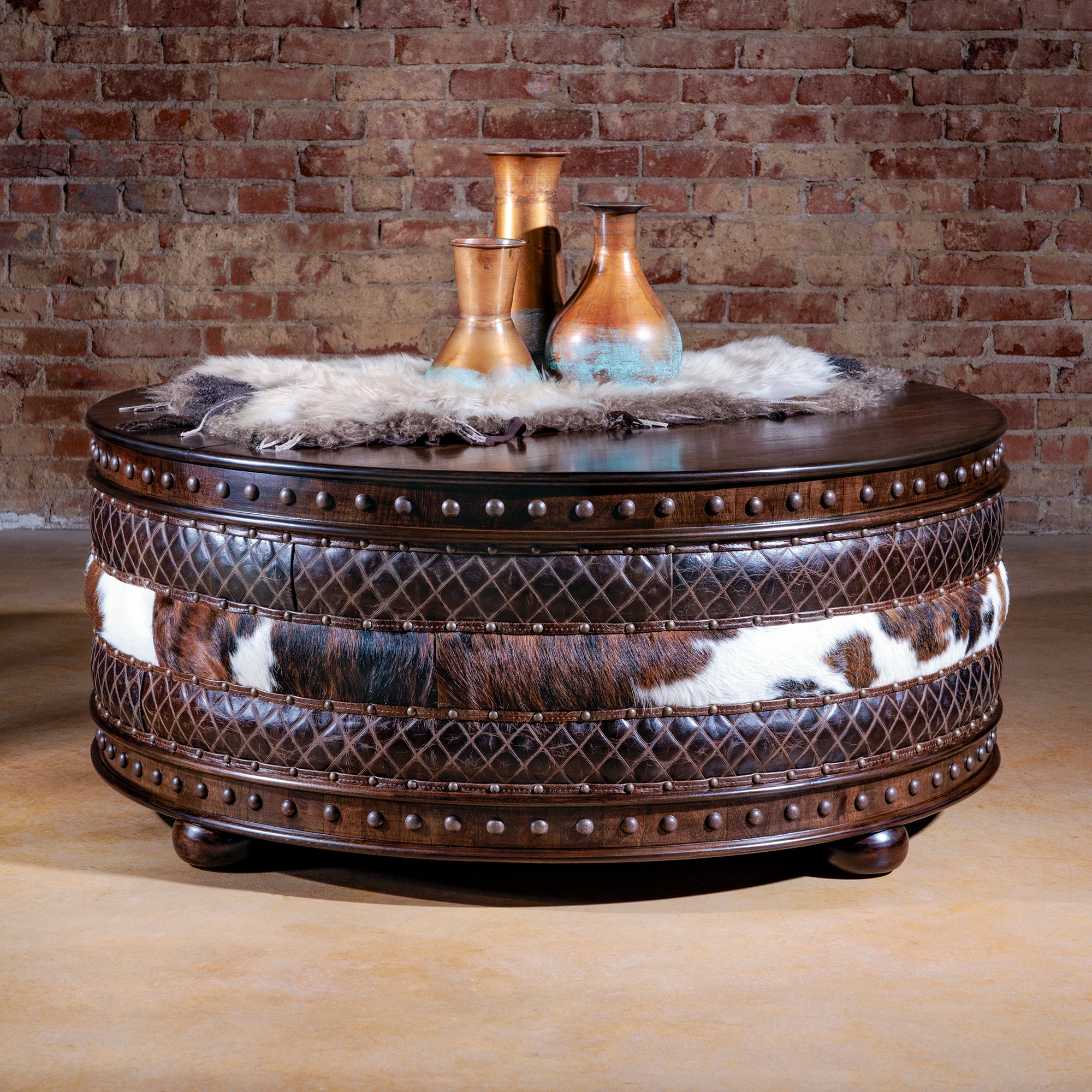 Round cowhide and leather coffee table with closed lid and nailhead trim