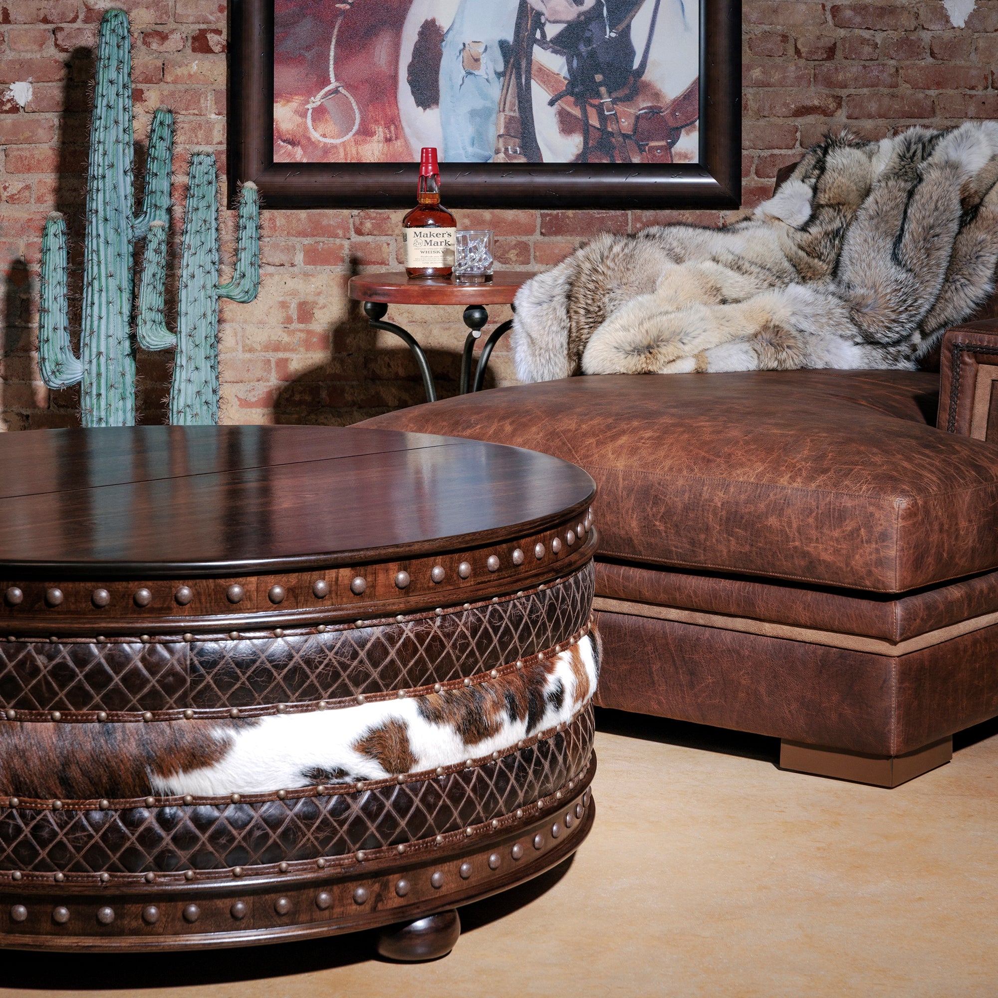 Styled Western living room scene with cowhide coffee table and leather sectional