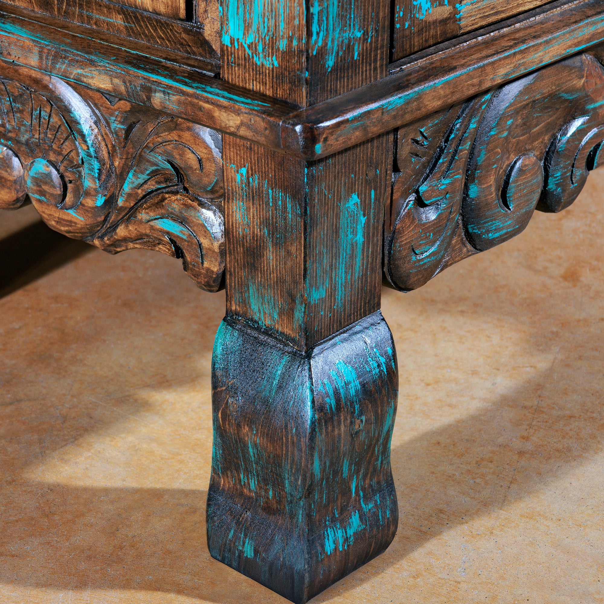 Close-up of leg scrollwork on turquoise Western buffet