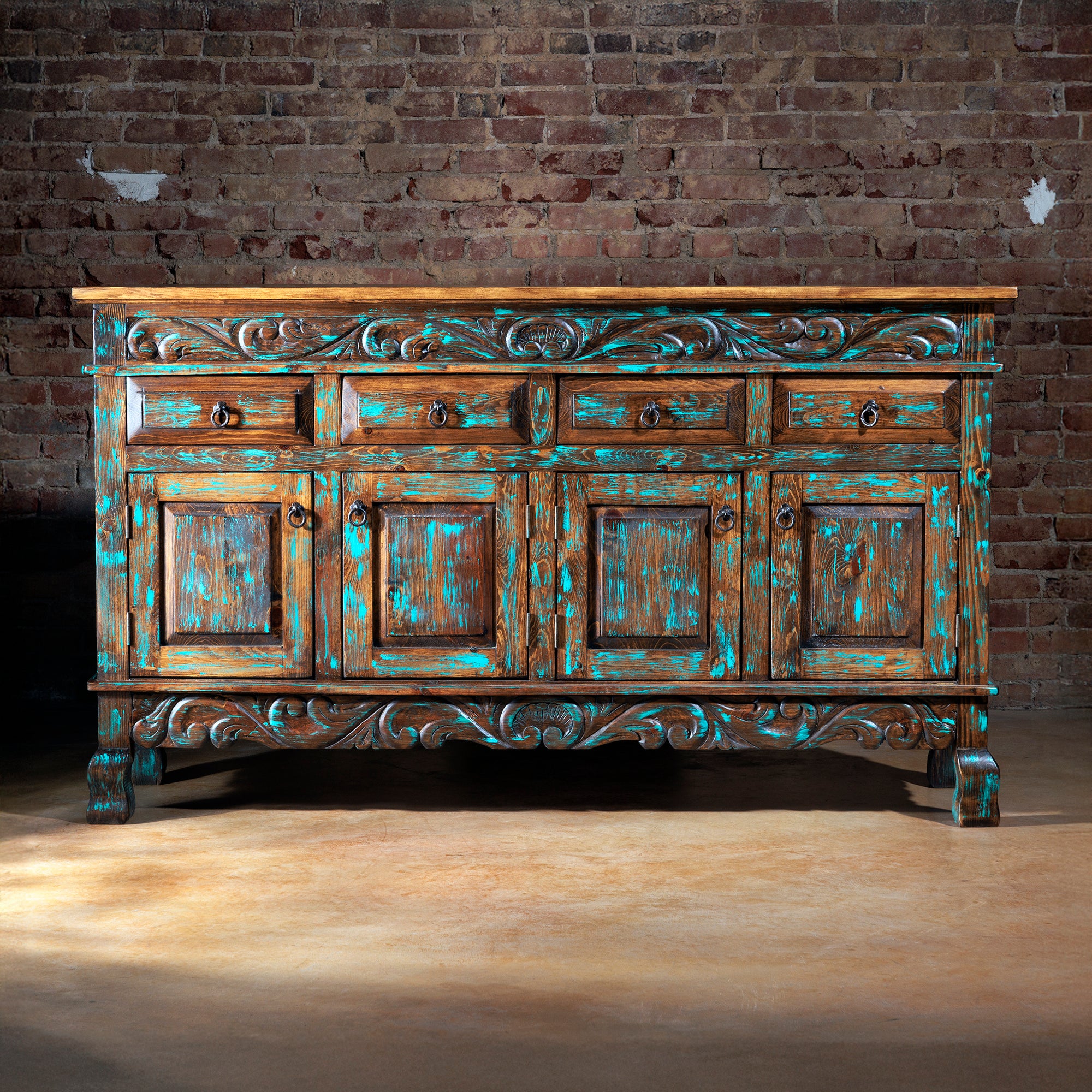 Front view of rustic turquoise hand-carved buffet with iron hardware