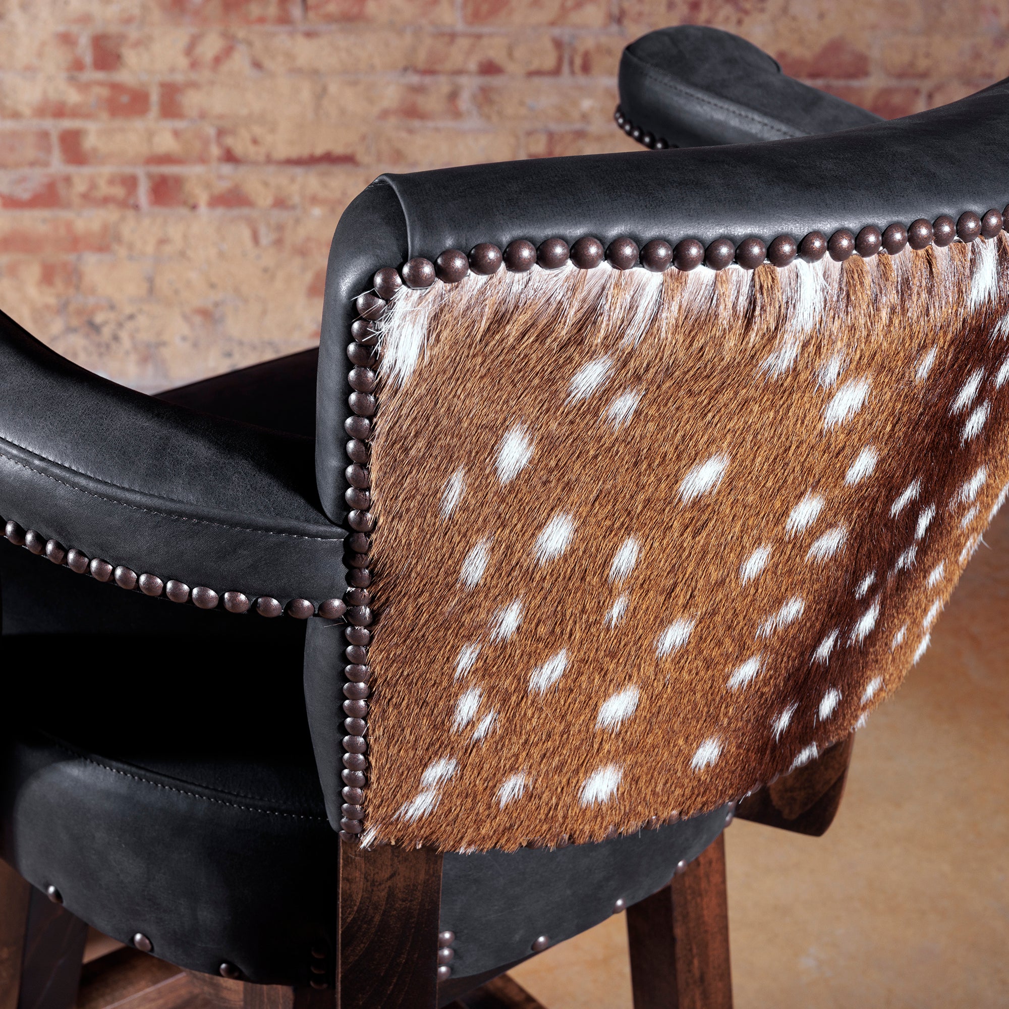 Detail of authentic axis hide upholstery framed with decorative nailhead accents.