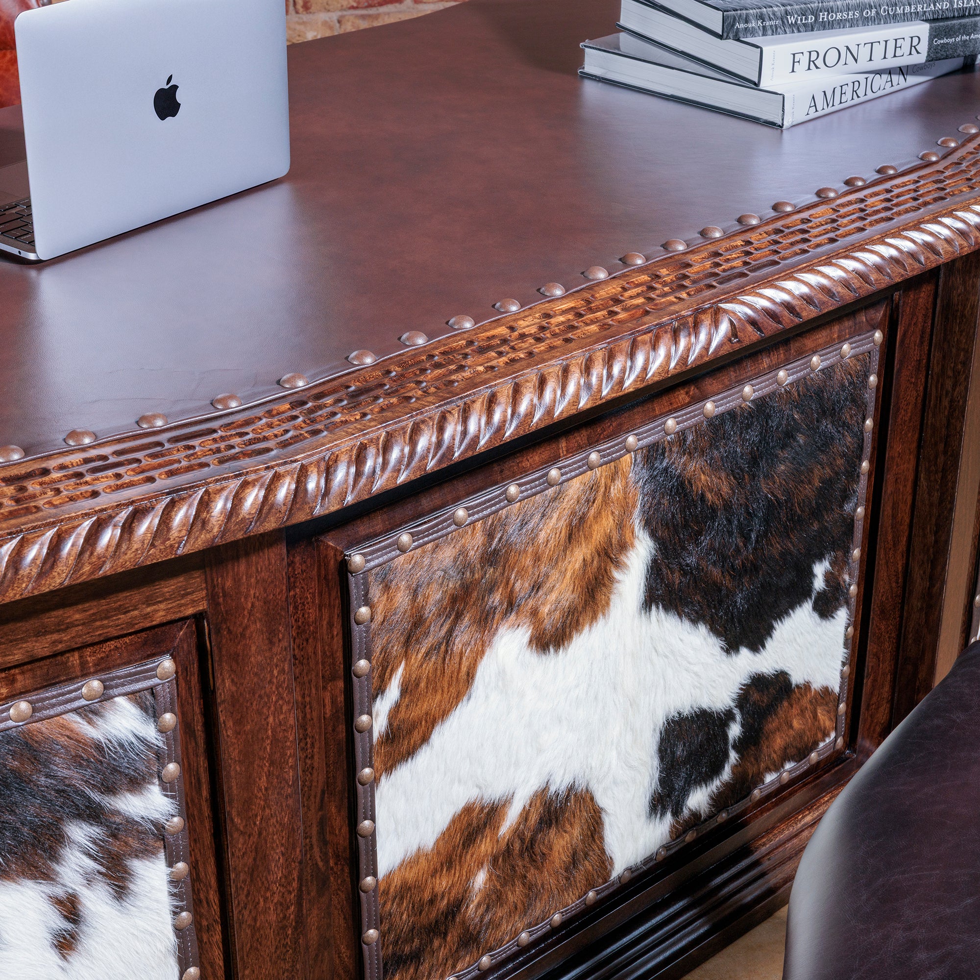 Genuine cowhide panel with nailhead trim on High Plains executive desk