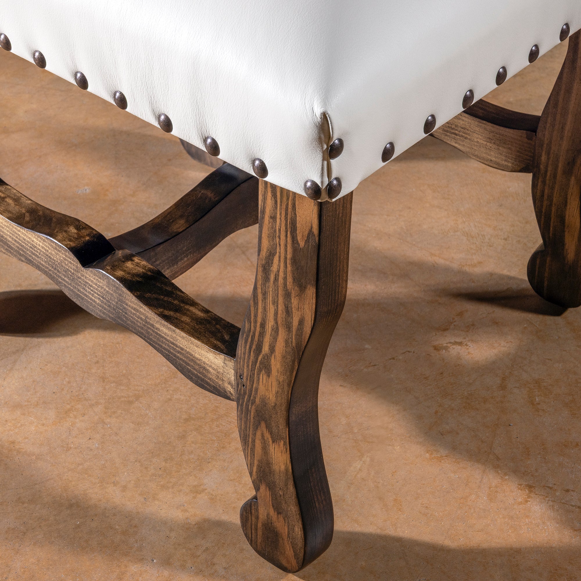 Seat corner and carved wood legs detail on High Plains Ivory white leather dining chair