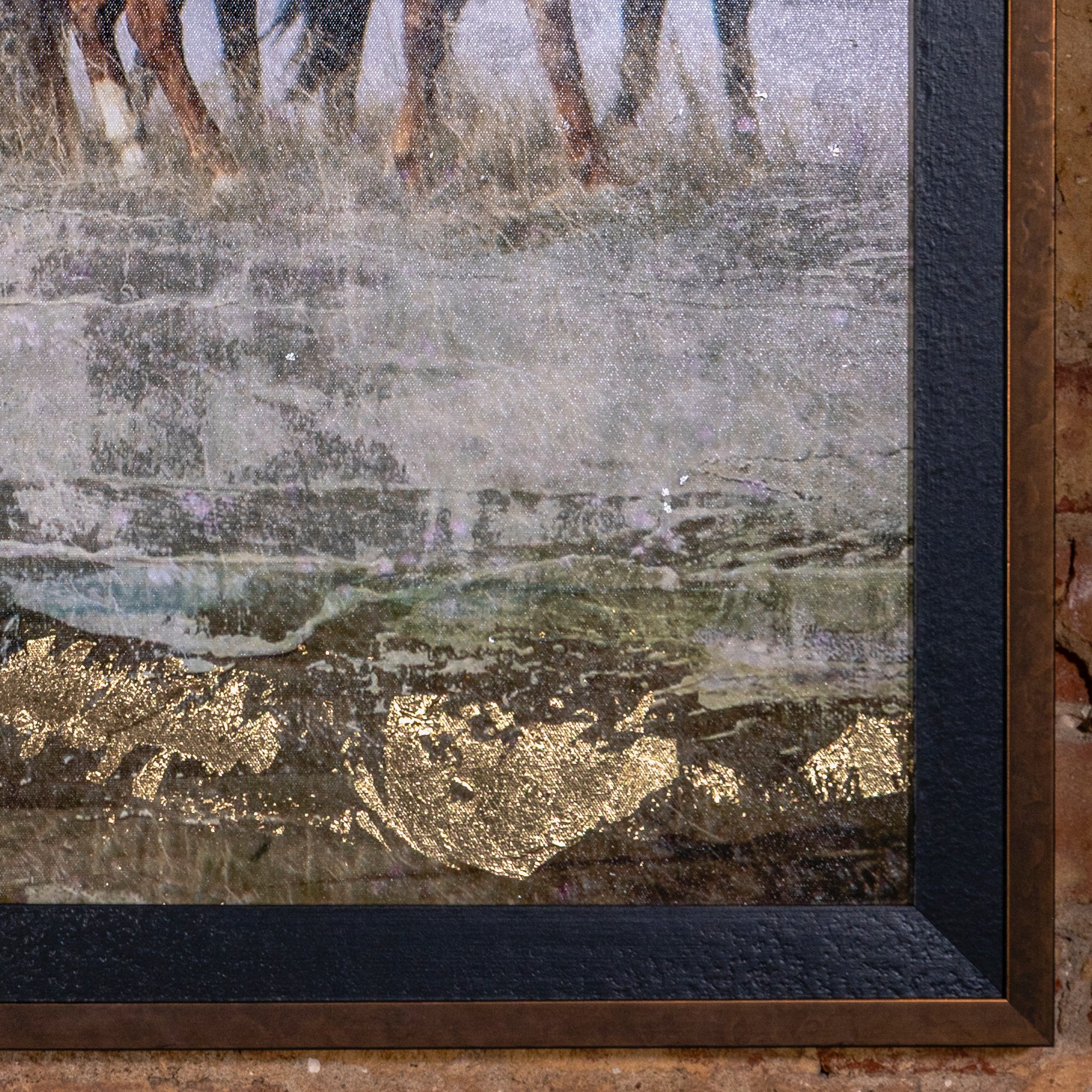 Close-up of framed Western horse artwork showing gold-leaf texture and weathered surface.