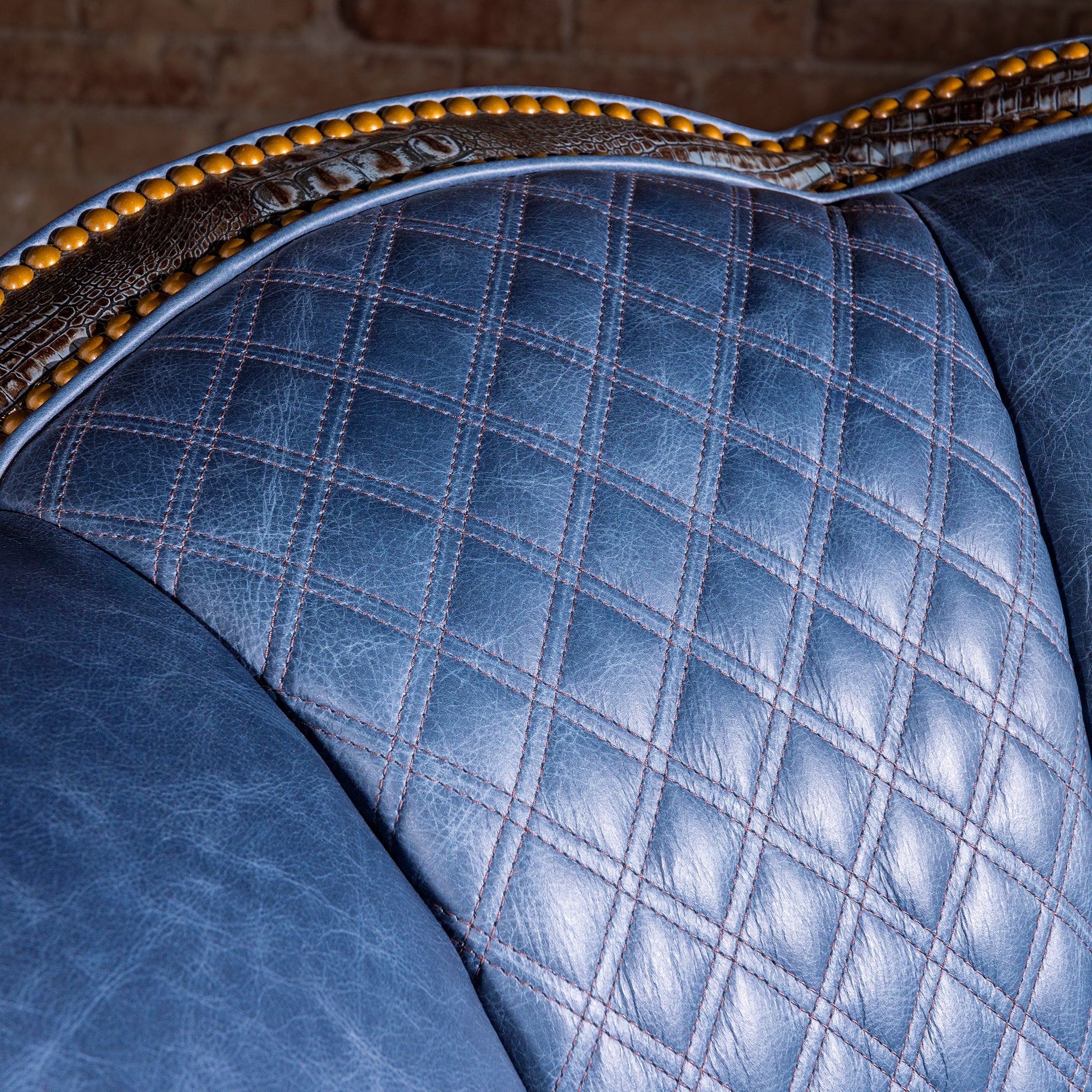 Diamond-quilted blue leather backrest detail with luxury stitching, swivel chair