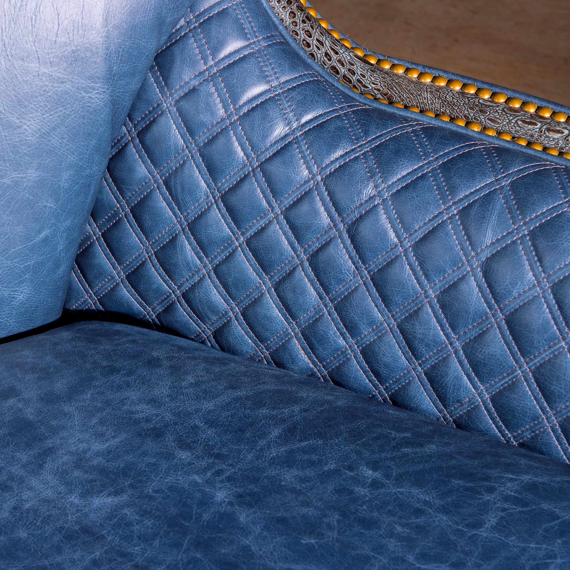 Inside arm detail with quilted blue leather and croc-embossed trim, Western swivel chair
