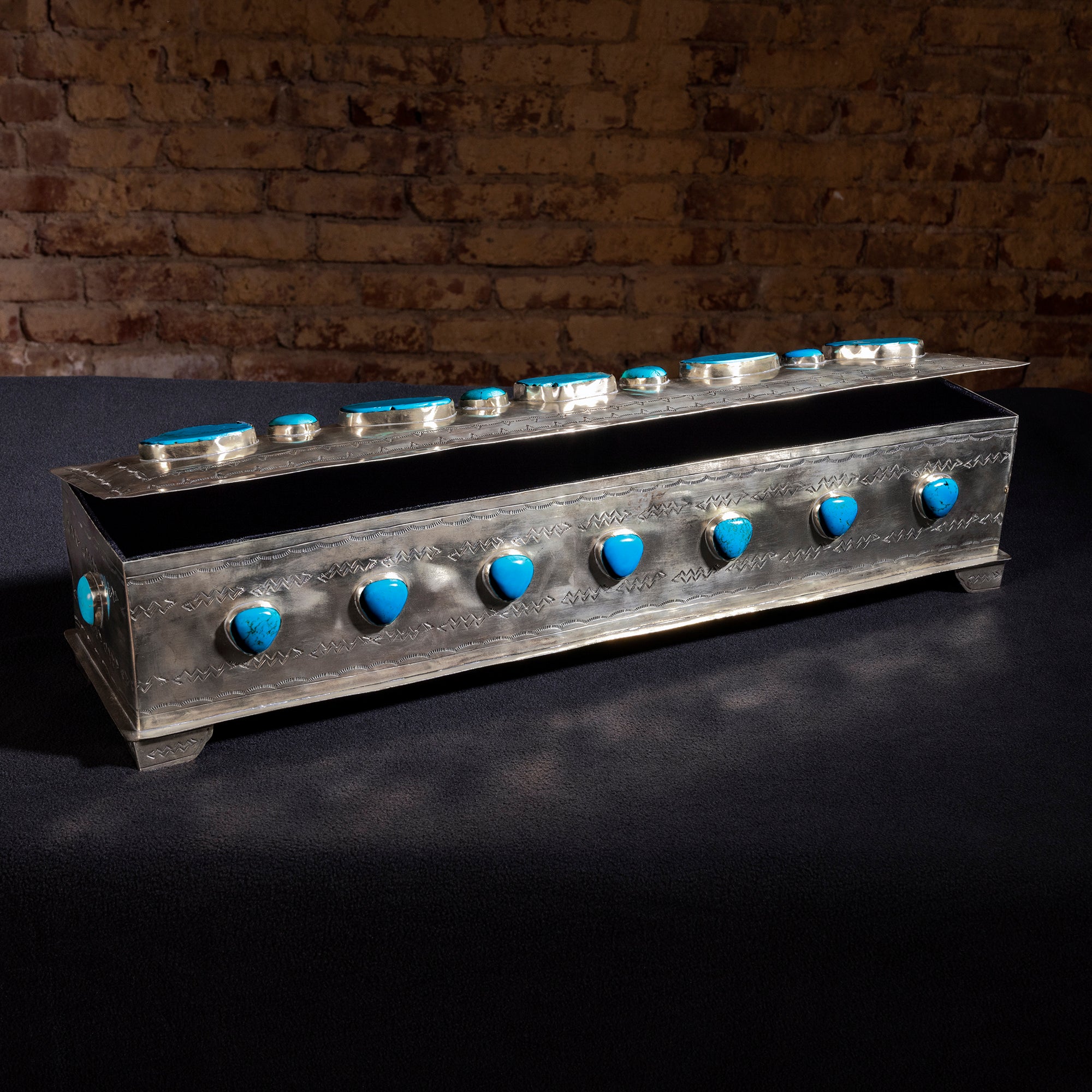 Open High Mesa Turquoise Vault by J. Alexander showing hand-tooled silver craftsmanship and patina finish
