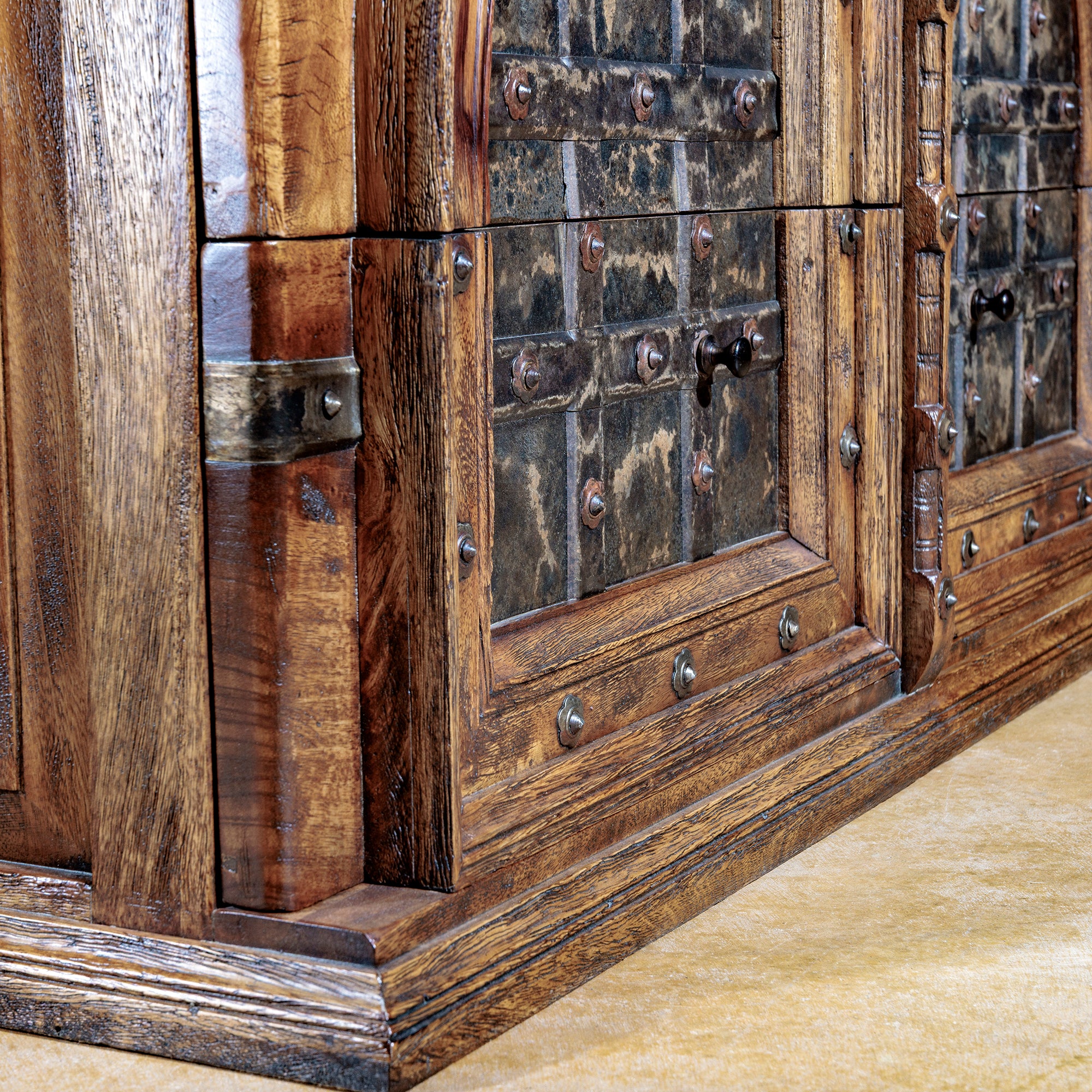 Base detail of rustic mango wood nightstand with iron hardware