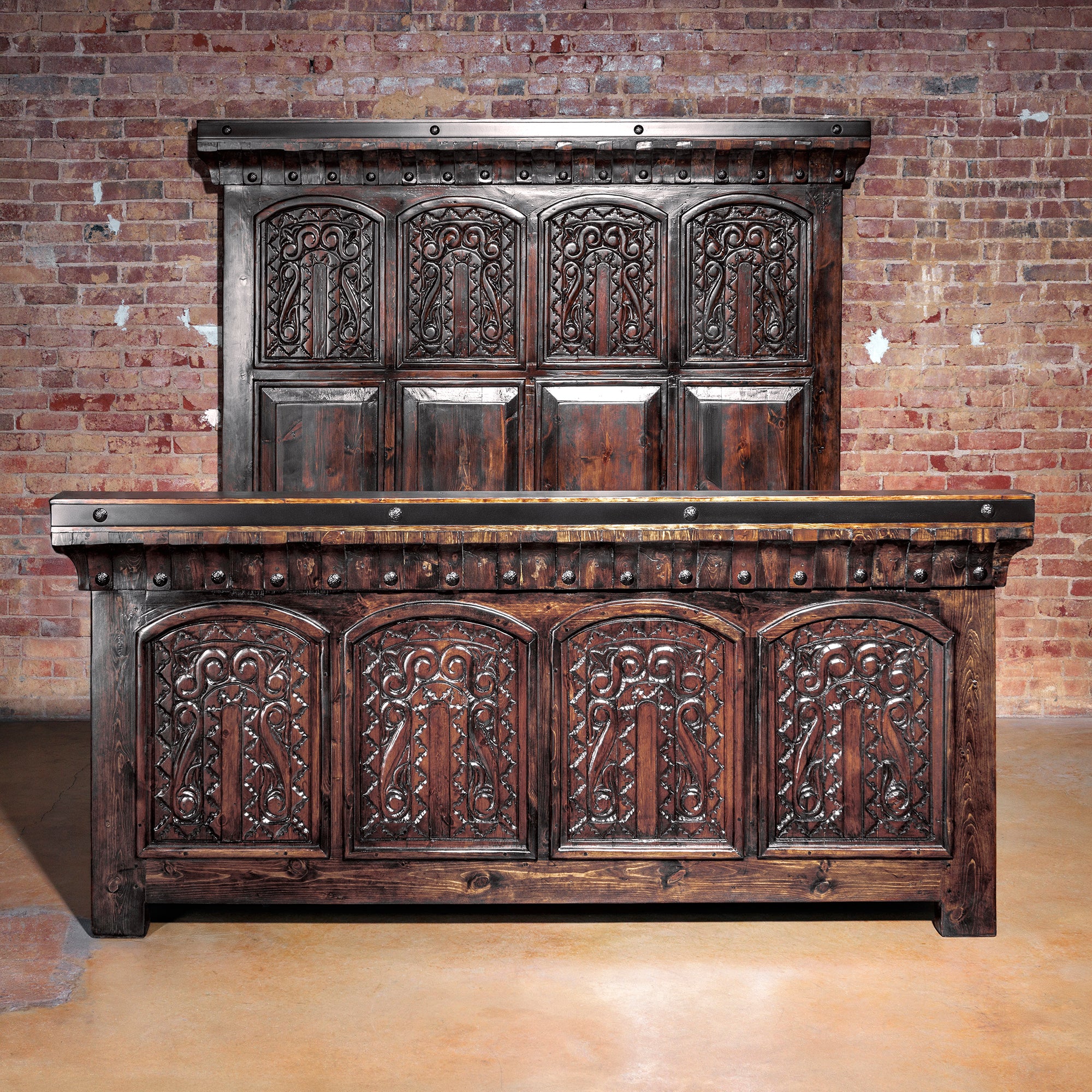 Full view of Ironwood Carved Bed frame with hand-carved wood and iron accents